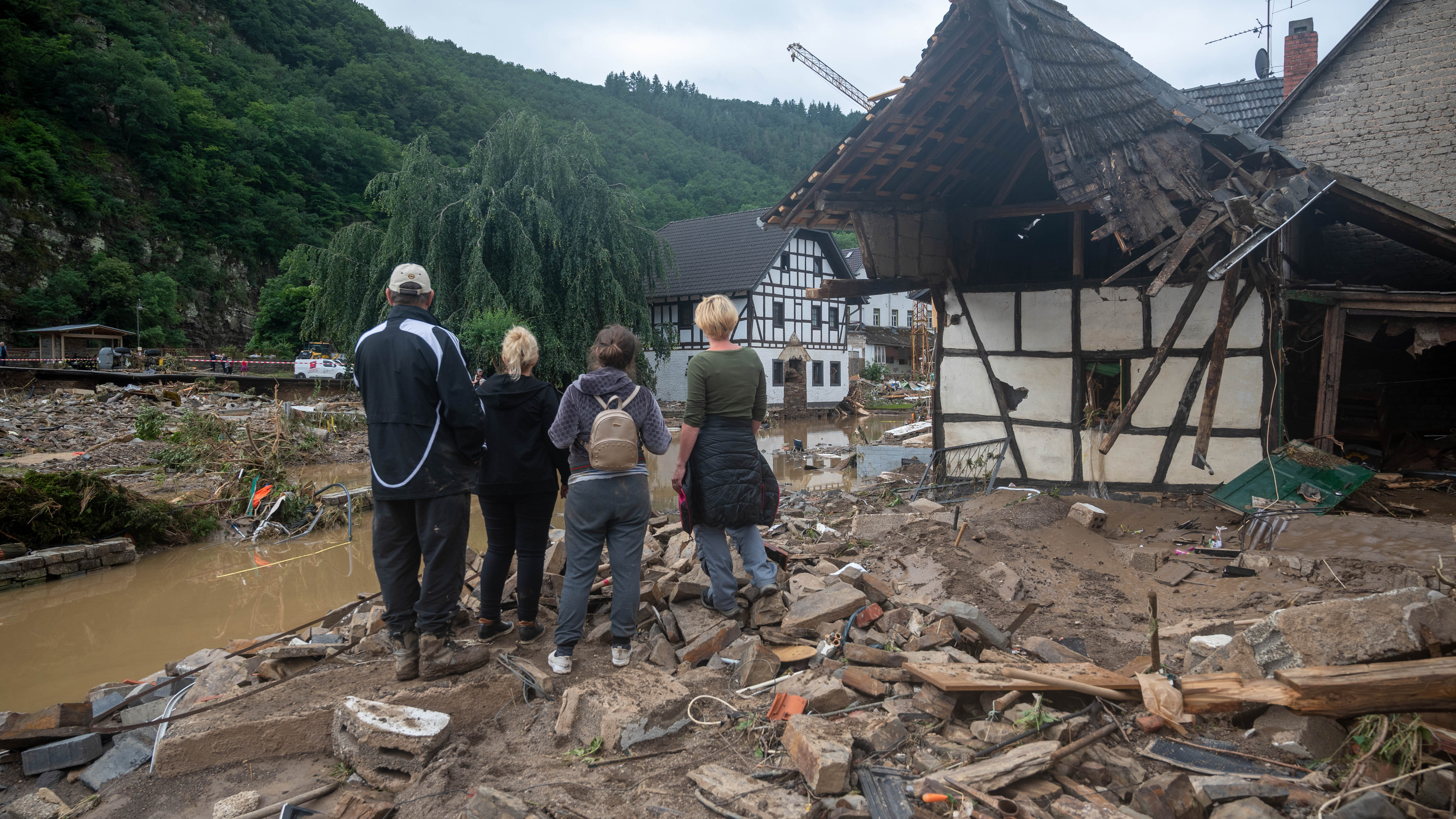 Rheinland-Pfalz, Schuld: Die Menschen schauen in dem Ort im Kreis Ahrweiler nach dem Unwetter auf die Zerstörungen. | dpa