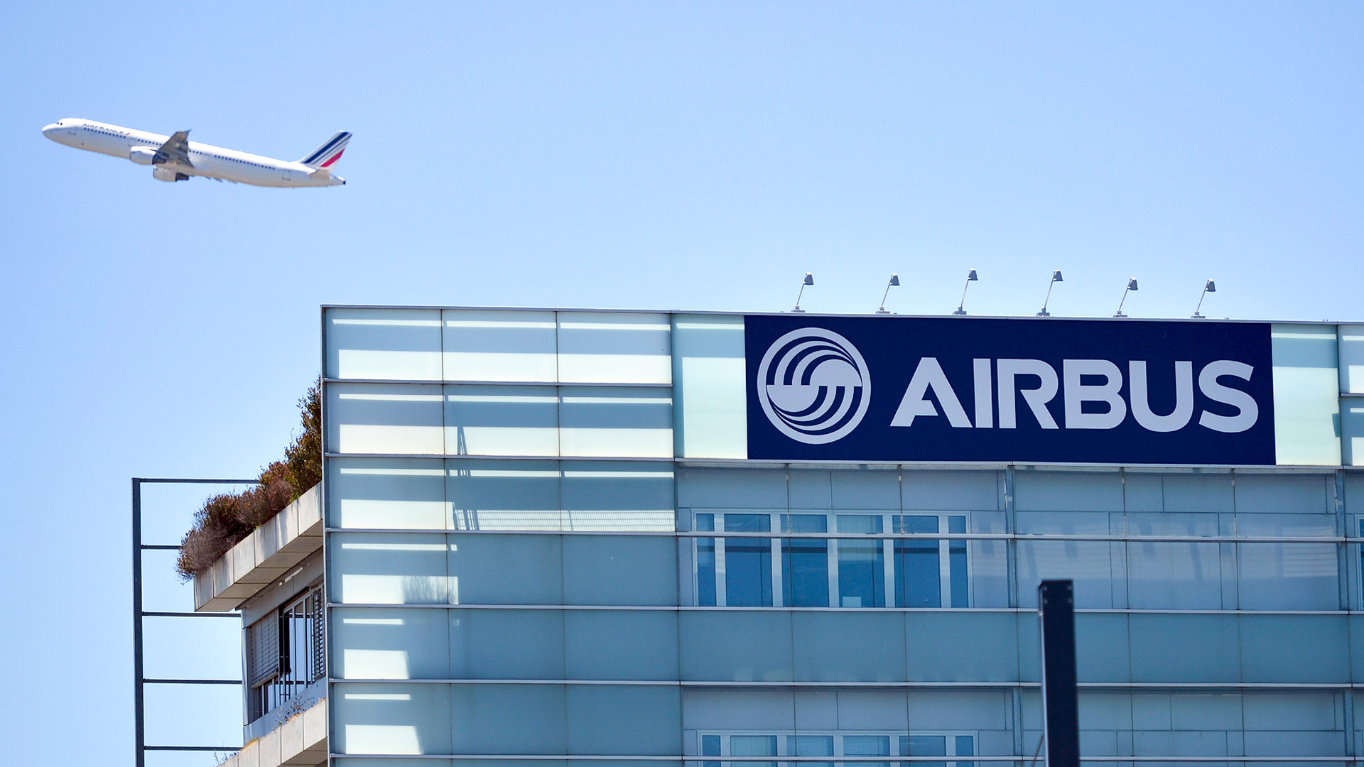 Ein Flugzeug steigt über einem Airbus-Gebäude in Toulouse in die Luft. | Airbus