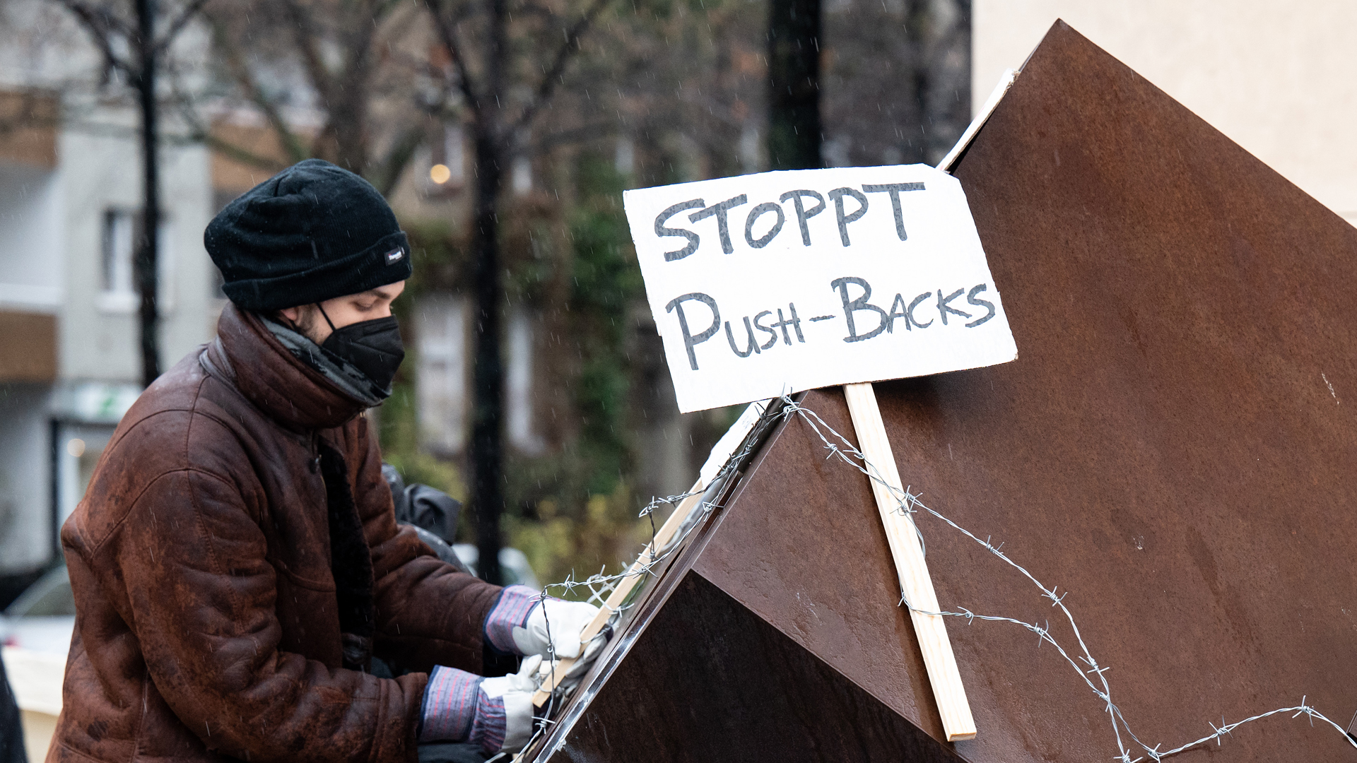 Ein Aktivist befestigt ein Schild mit der Aufschrift "Stoppt Push-backs". | picture alliance/dpa