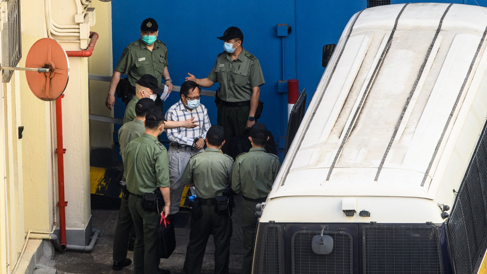 Dieses Bild vom Mai 2021 zeigt, wie Albert Ho in Handschellen zu einer Gerichtsverhandlung gebracht wird. | AFP