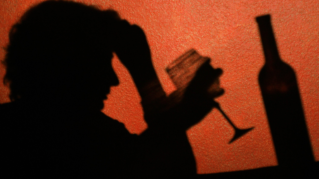 Der Schatten einer Frau, die ein Glas Wein trinkt, ist an der Wand in einer Kneipe zu erkennen | dpa