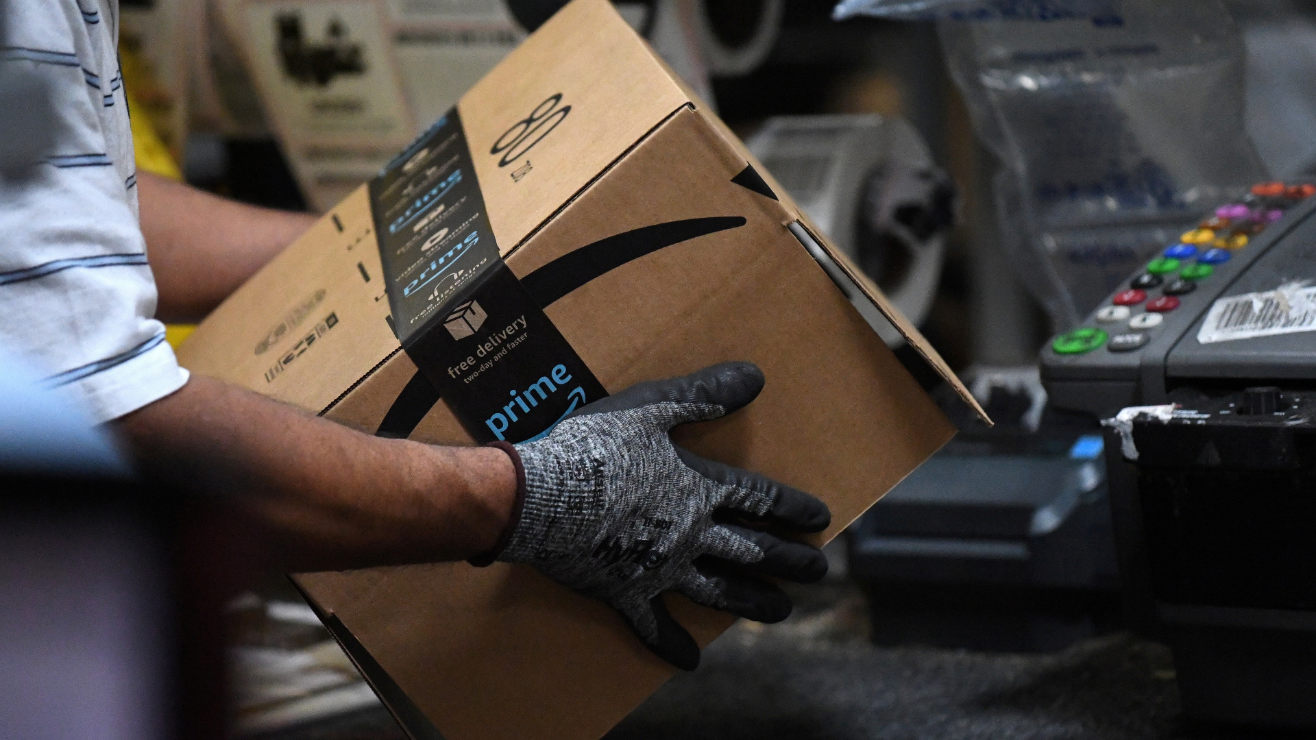 Ein Amazon-Mitarbeiter baut eine Box zusammen. | REUTERS