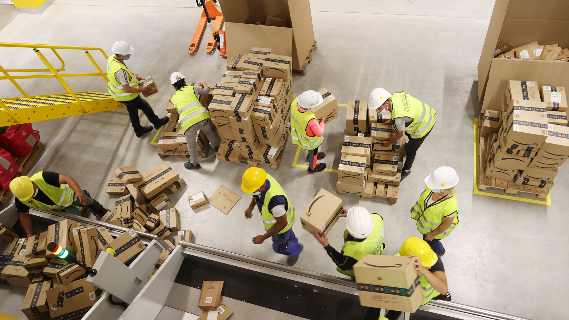  Amazon Mitarbeiter transportieren Versandkartons bei einem Probebetrieb in einer Logistikhalle.  | picture alliance/dpa/dpa-Zentral