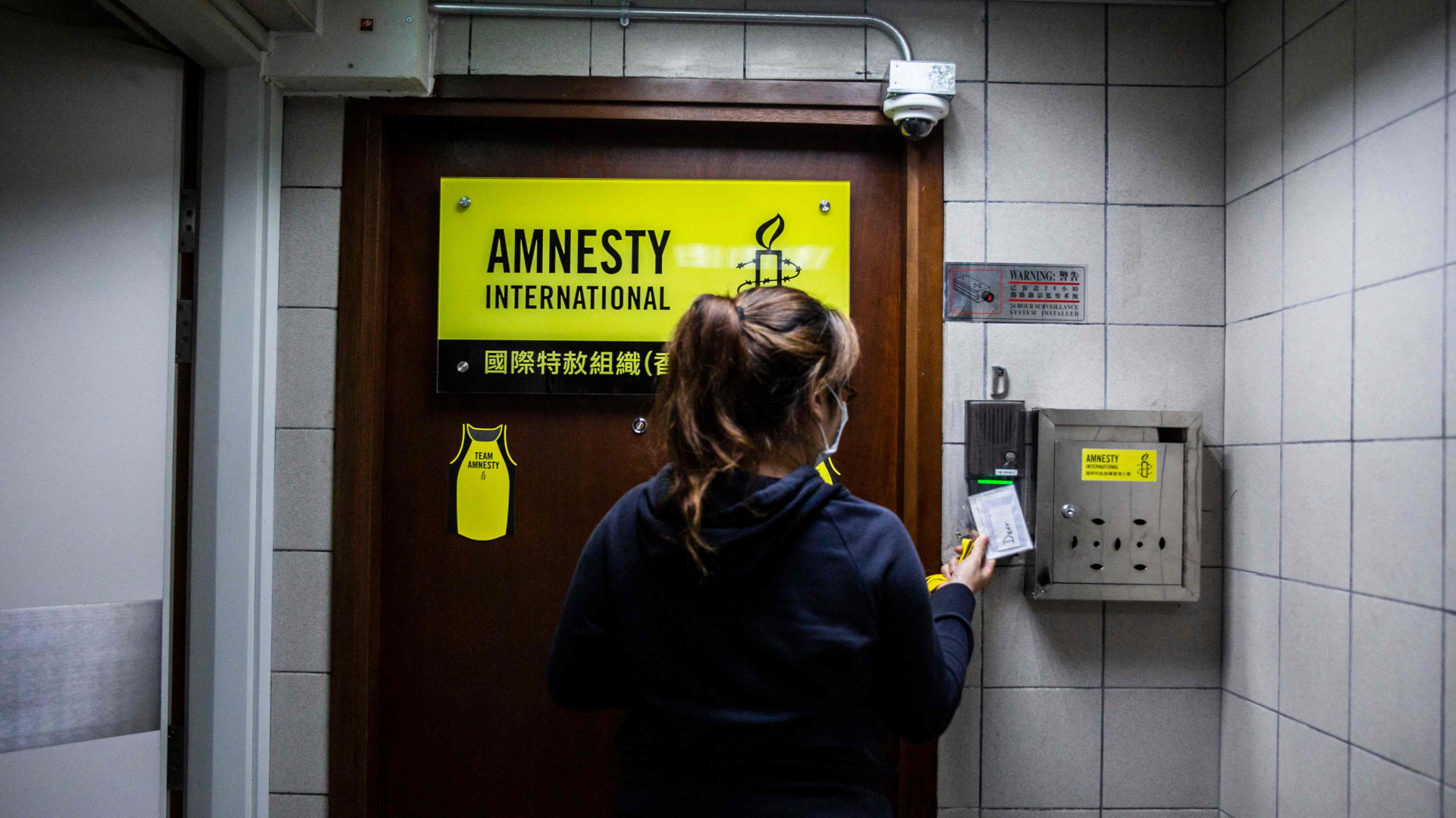Eine Frau steht vor dem Eingang eines Büros von Amnesty International | AFP