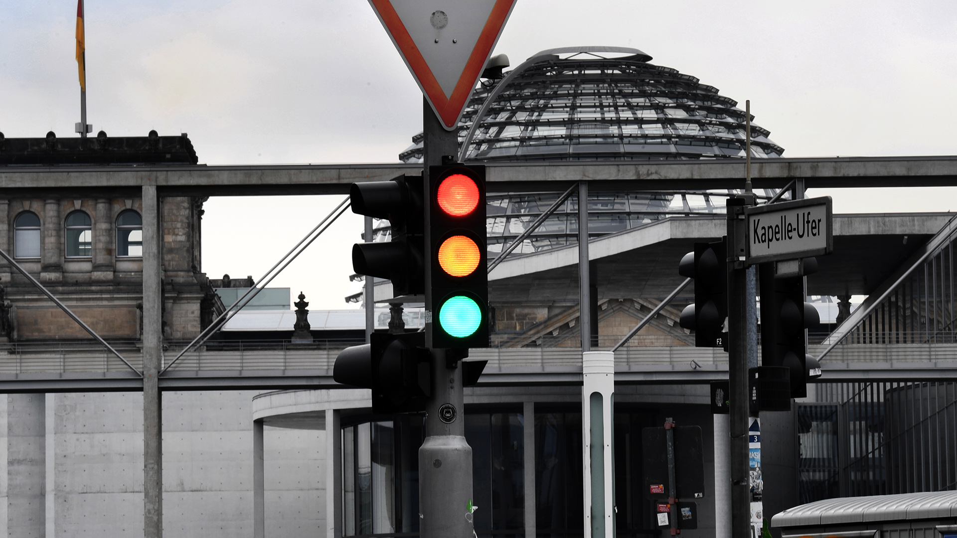 Eine Ampel zeigt die Farben rot, gelb und grün vor der Kuppel des Reichstagsgebäudes in Berlin | Bildquelle: dpa