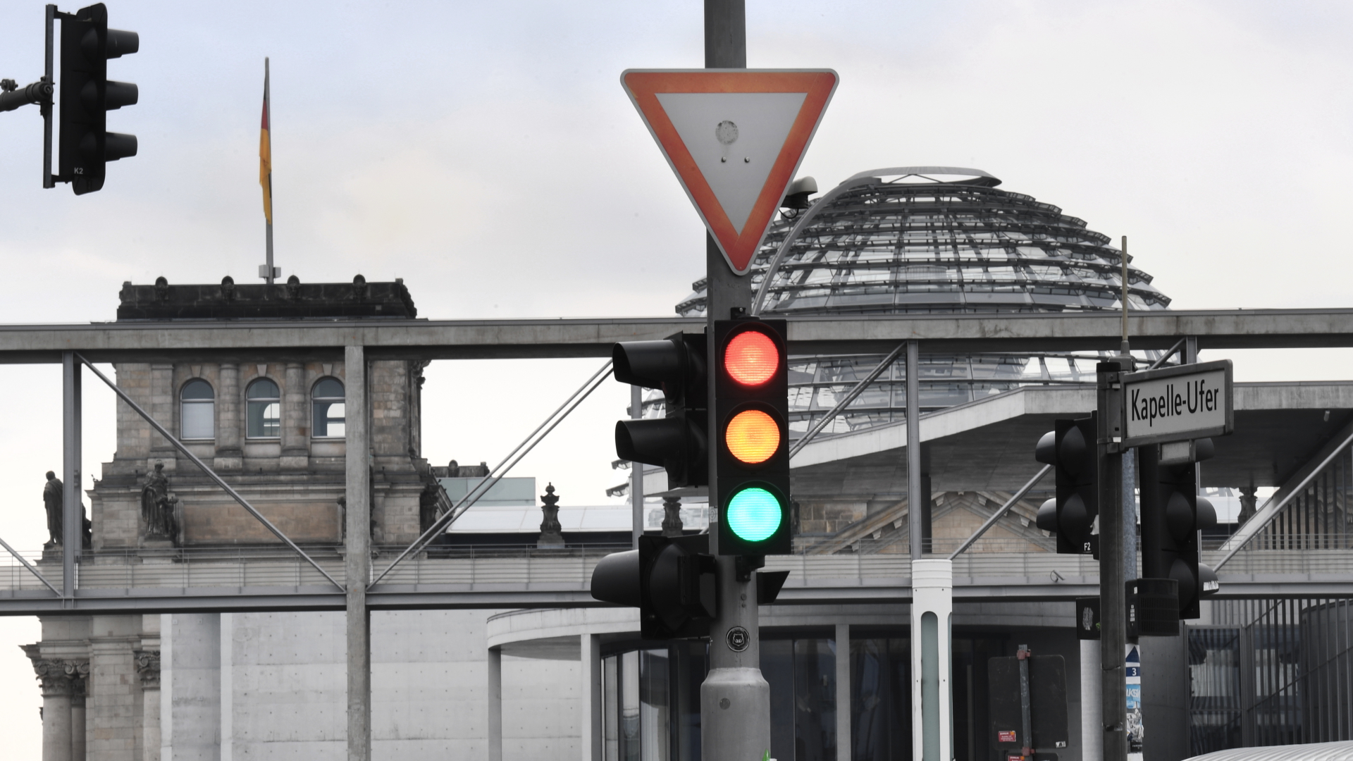 Eine Ampel im Regierungsviertel vor der Kuppel des Reichstagsgebäudes