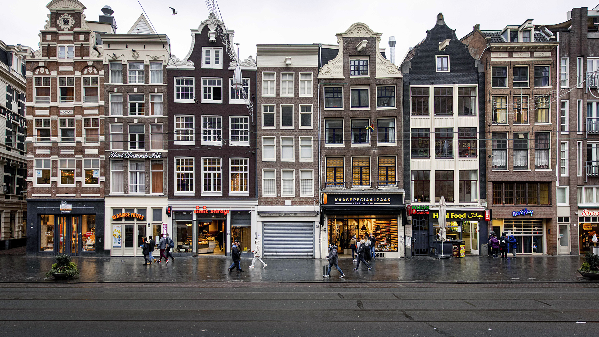 Einige Personen gehen an Geschäften im Stadtzentrum von Amsterdam vorbei. | picture alliance/dpa/ANP