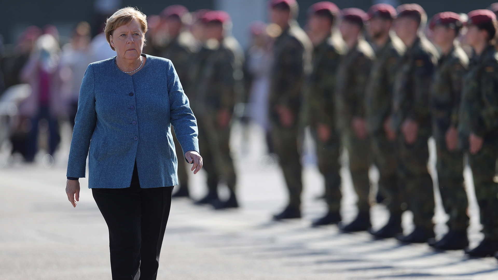 Angela Merkel läuft an stehenden Bundewehsrsoldaten vorbei. | EPA