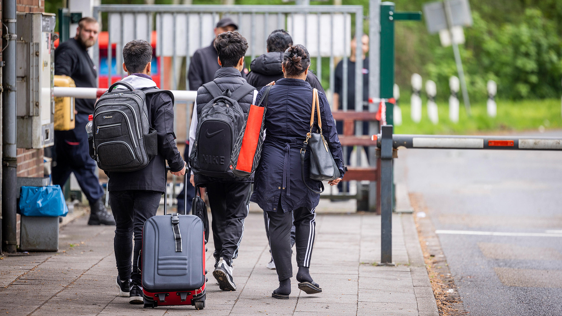 Flüchtlinge mit Gepäck am Eingang zur LAB Bramsche, dem Ankunftszentrum der Landesausnahmebehörde Bramsche-Hesepe in Niedersachsen.