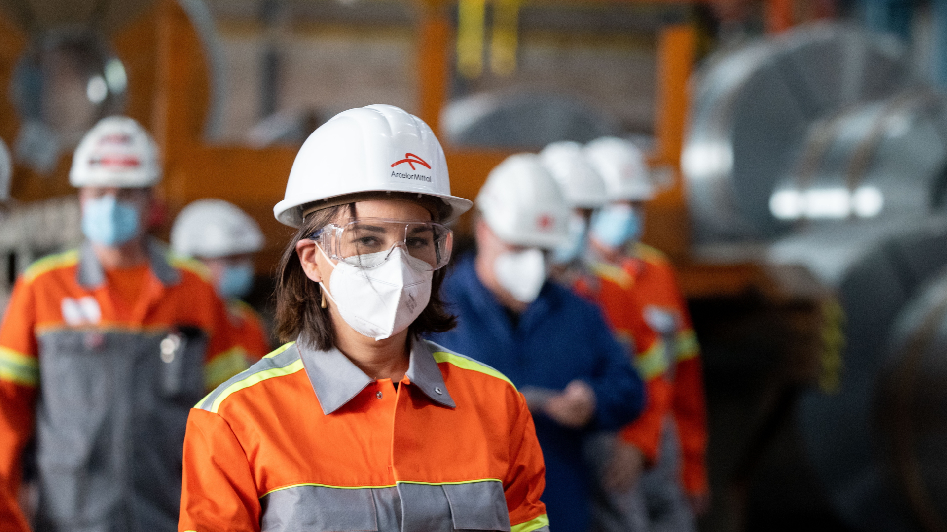 Annalena Baerbock mit FFP2-Maske, Schutzbrille und Schutzhelm den Stahlkonzern ArcelorMittal