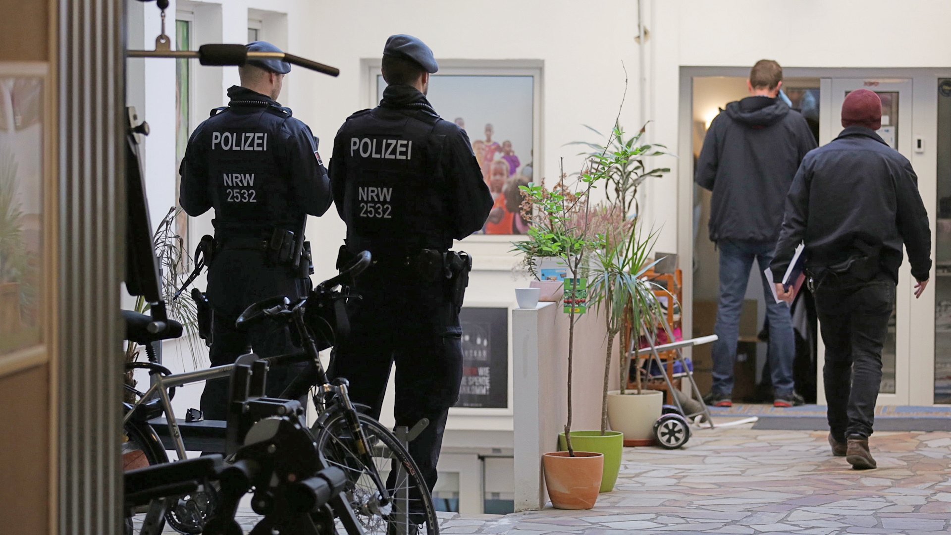  Polizeibeamte stehen vor dem Hauptsitz des Vereins Ansaar International in der Worringer Straße.
