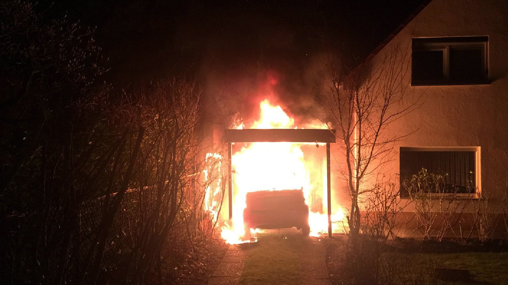 Ein brennendes Auto steht in einem Carport | picture alliance / Ferat Kocak/D