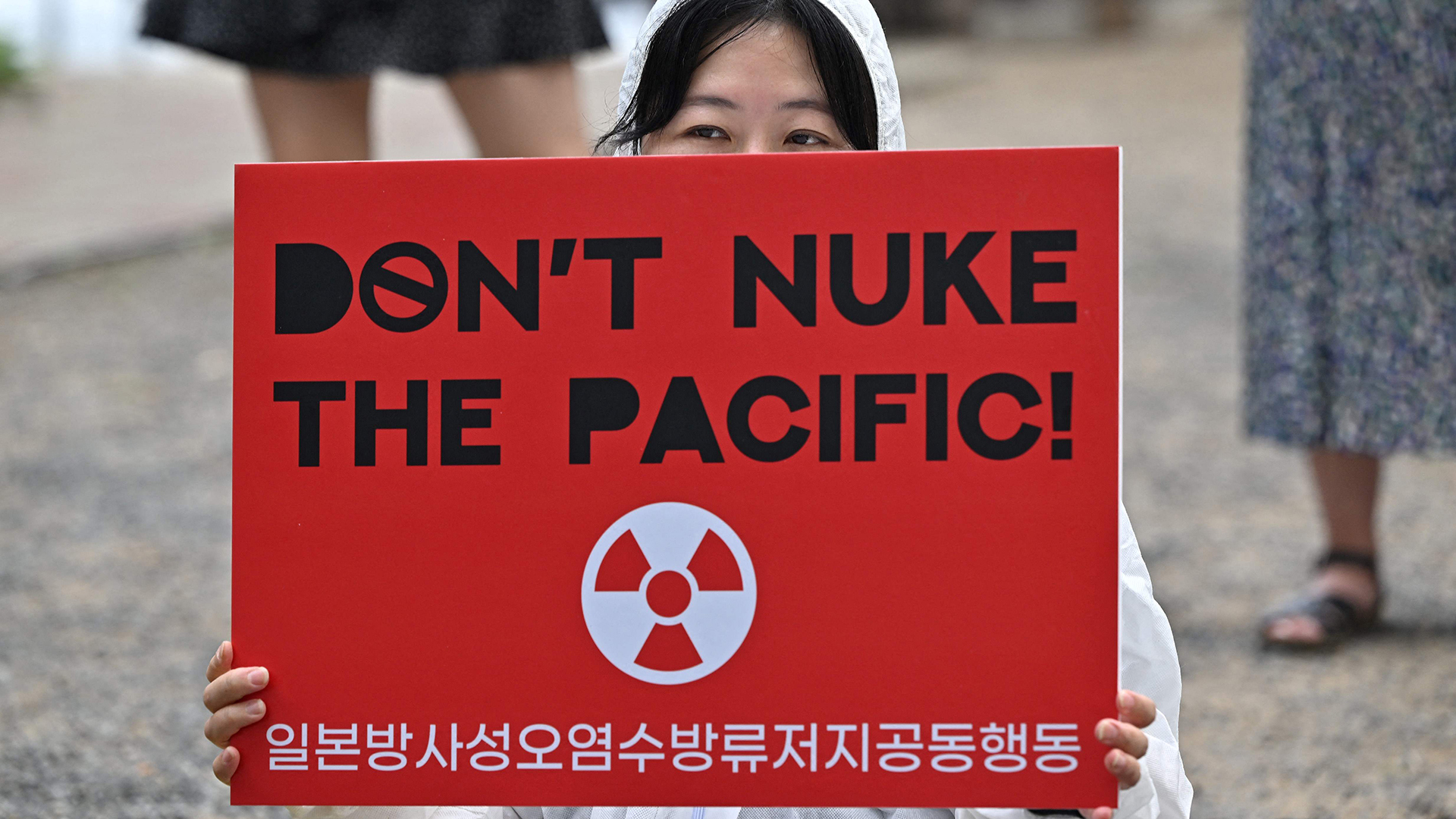 Ein Frau hält ein Schild mit der Aufschrift: Don't nuke the pacific | AFP