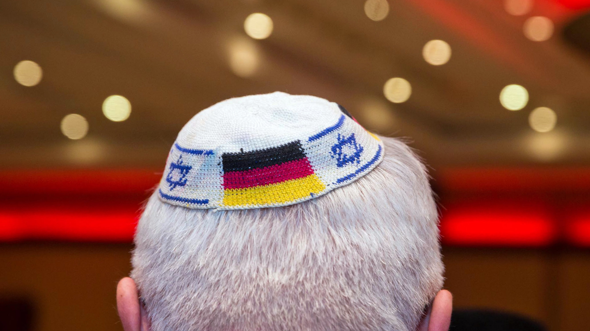 Ein Mann trägt eine Kippa auf der die Deutschlandflagge und die israelische Flagge abgebildet sind