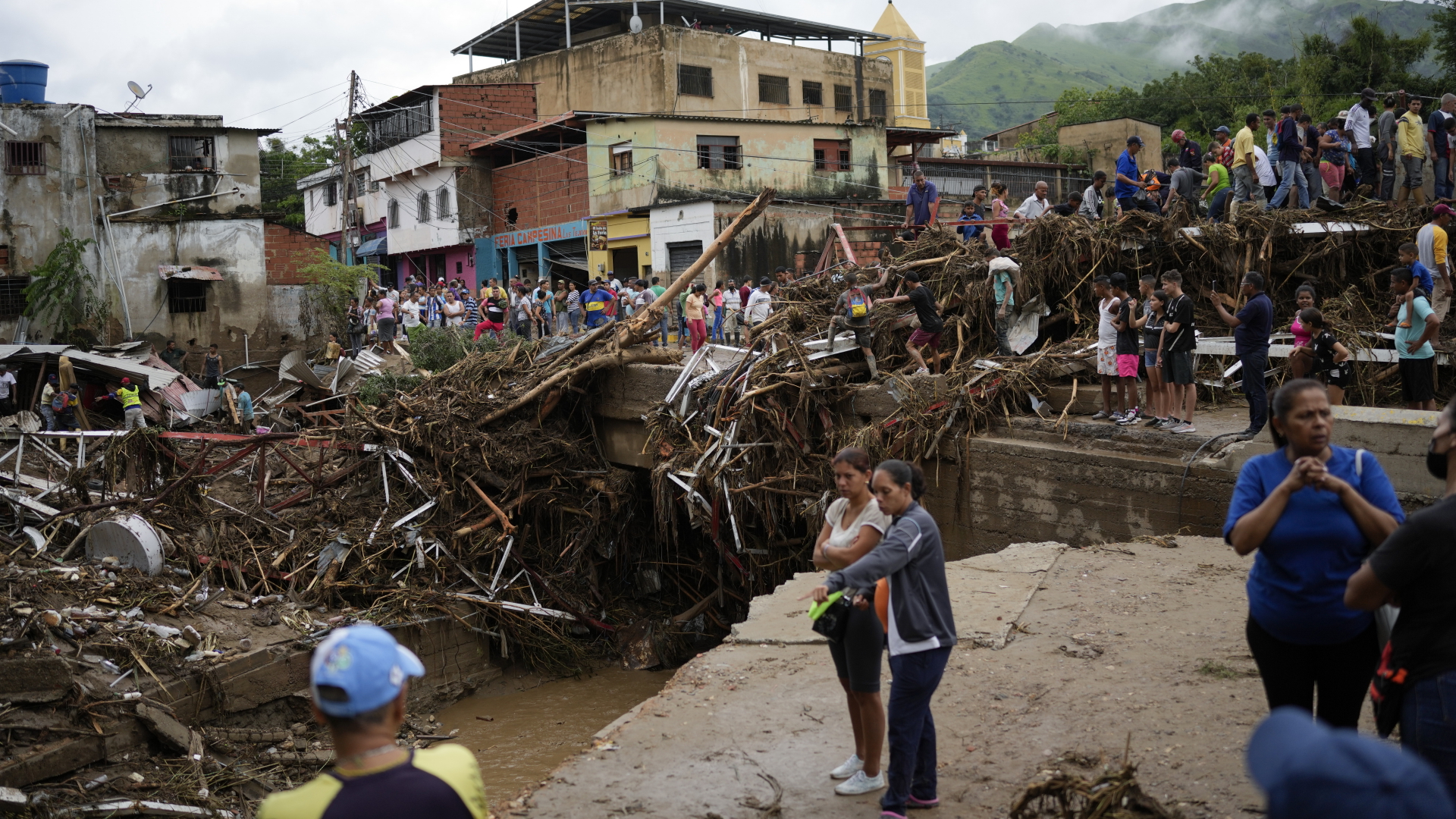 Anwohner in Las Tejerias (Venezuela) betrachten die Schäden, die durch einen Erdrutsch verursacht wurden. | dpa