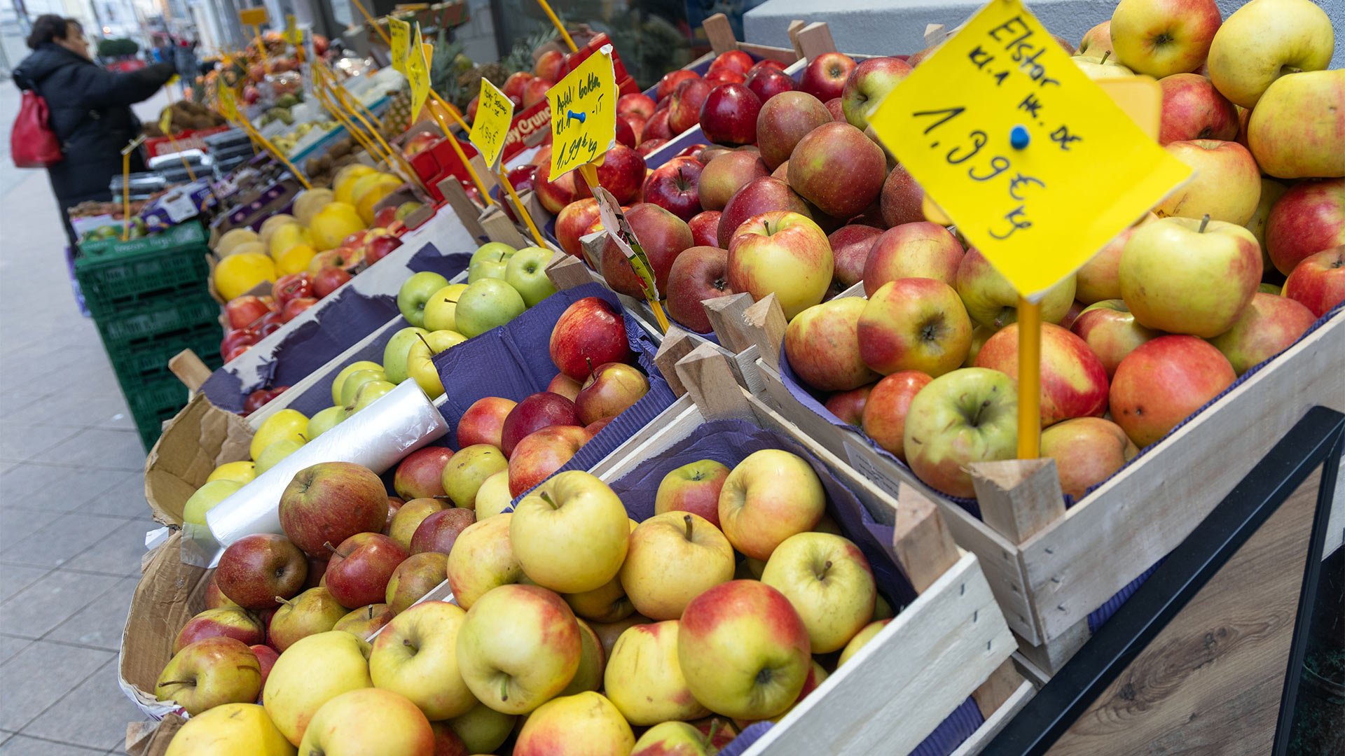 Verschiedene Apfelsorten und Gemüse werden vor einem Händler an einem Straßenverkaufsstand angeboten. | picture alliance/dpa