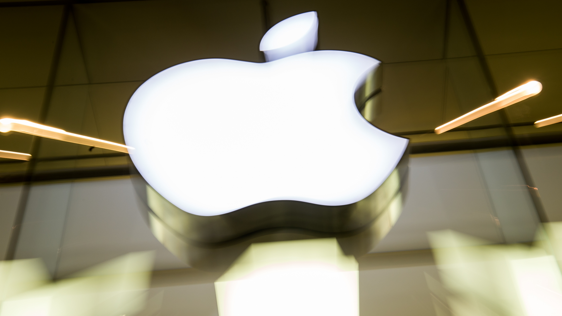 Das Apple-Logo leuchtet an der Fassade des Apple-Store in München | dpa