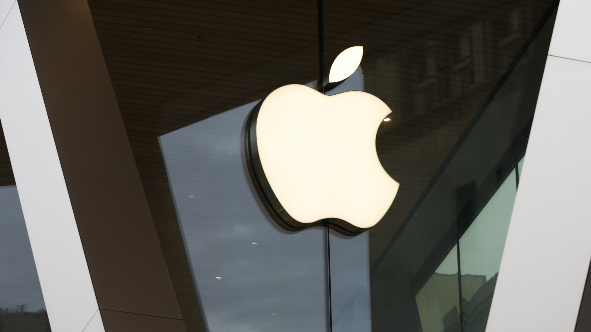 Apple-Logo hängt an einer Glasfront | AP