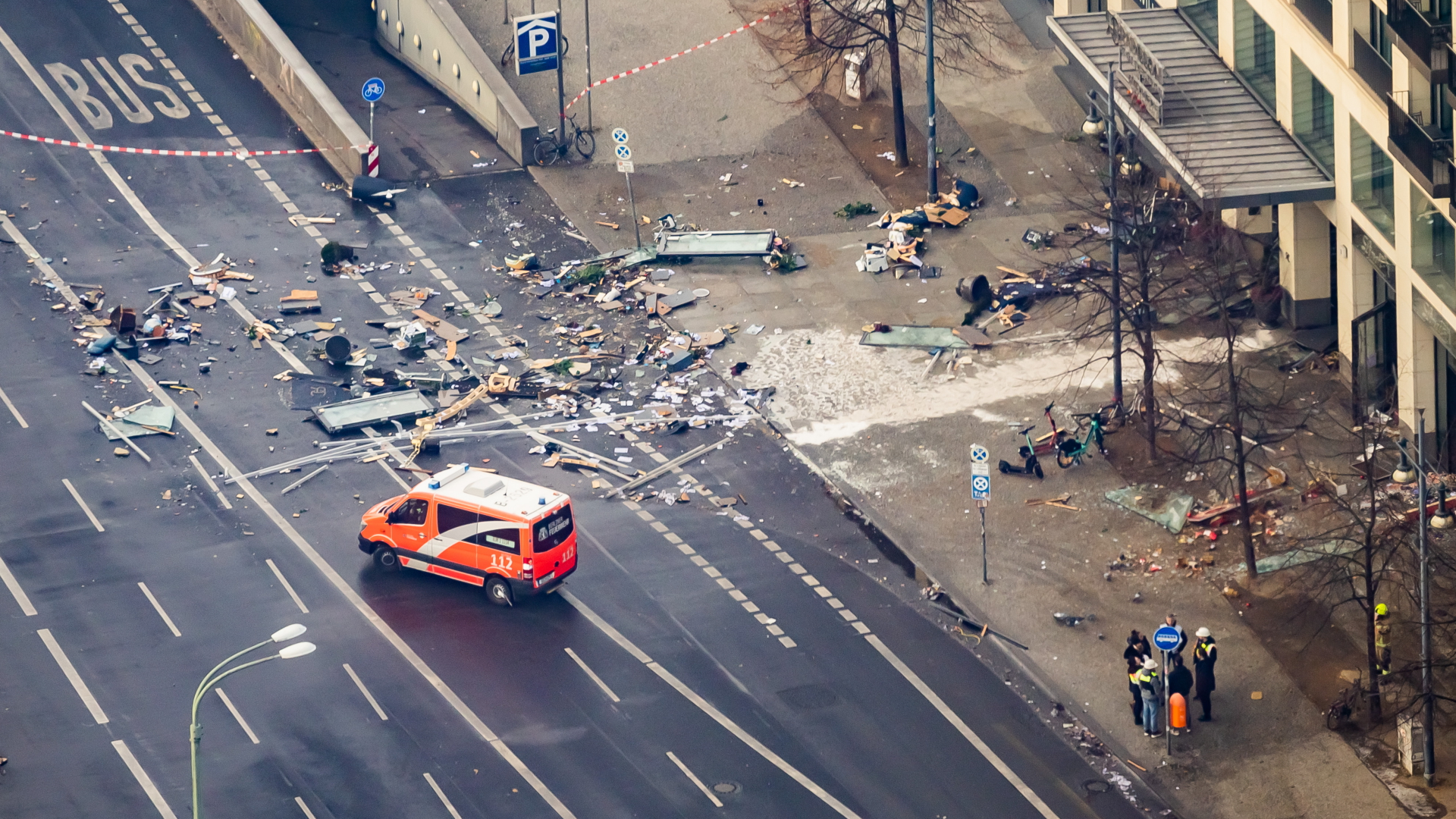 Trümmerteile liegen auf der abgesperrten Straße vor einem Berliner Hotel.