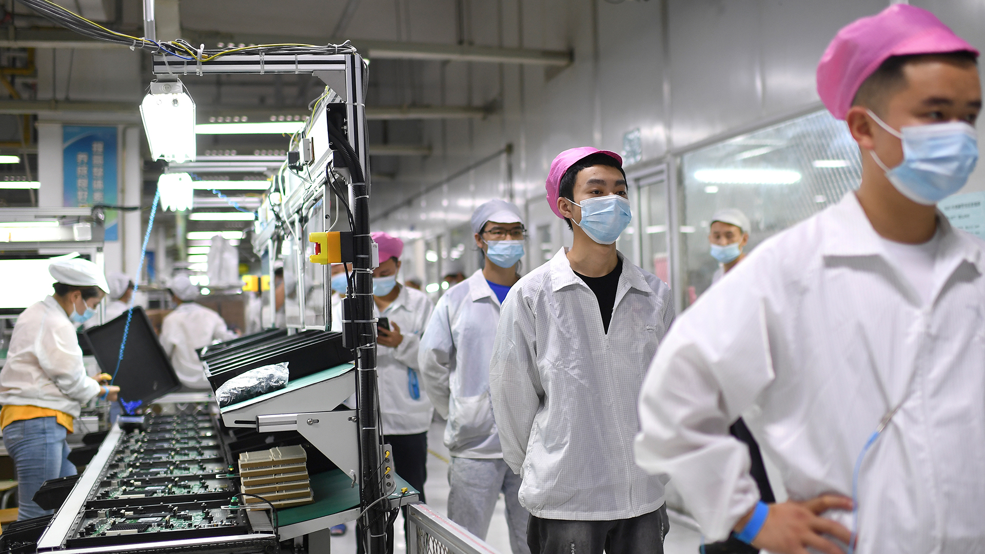 Arbeiter stellen sich in der Foxconn-Fabrik in Wuhan an, um sich auf das Coronavirus testen zu lassen. | dpa