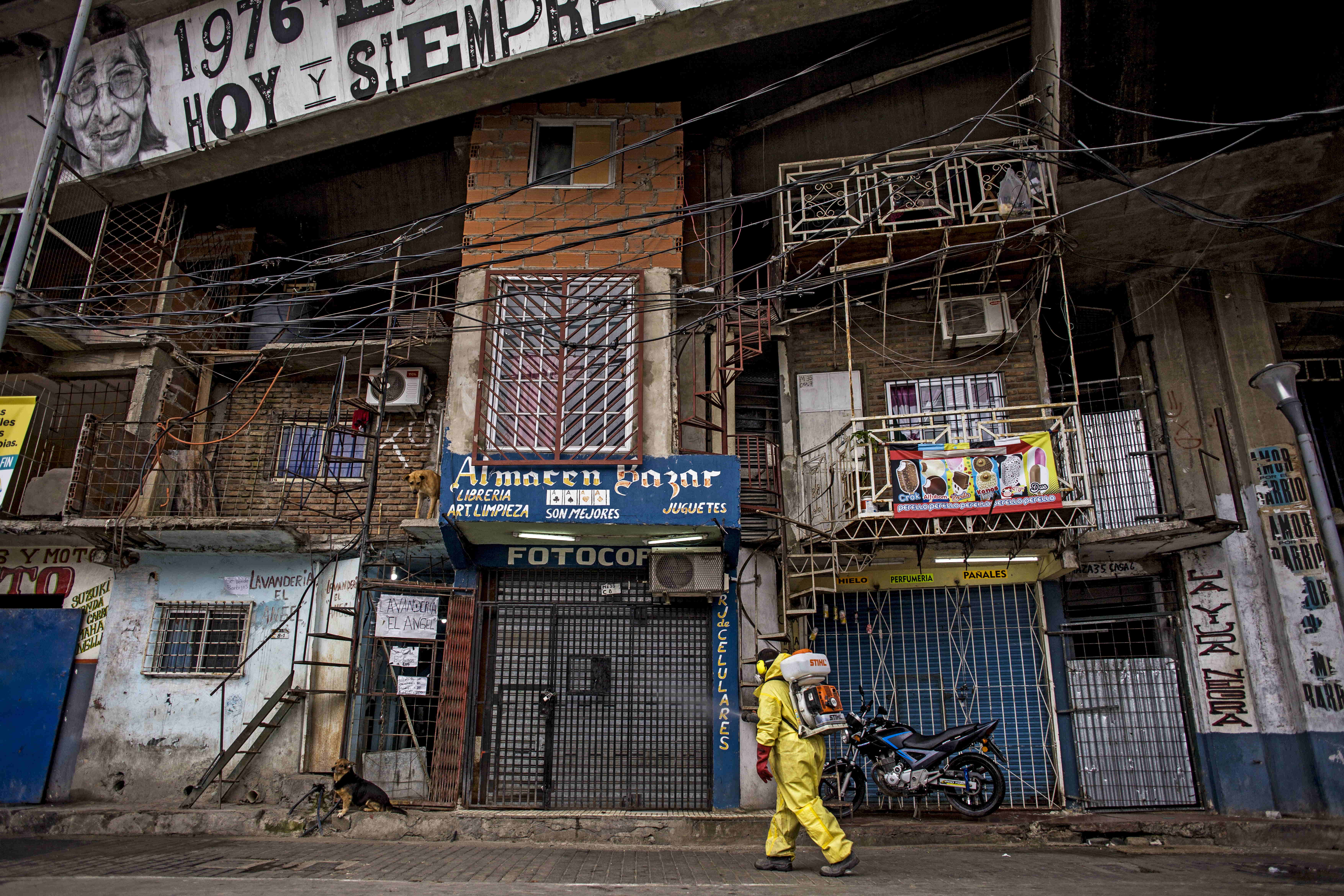 Ein Mann in Schutzanzug führt einen Desinfektionseinsatz in dem Armenviertel "Villa 31" im argentinischen Buenos Aires durch. | dpa