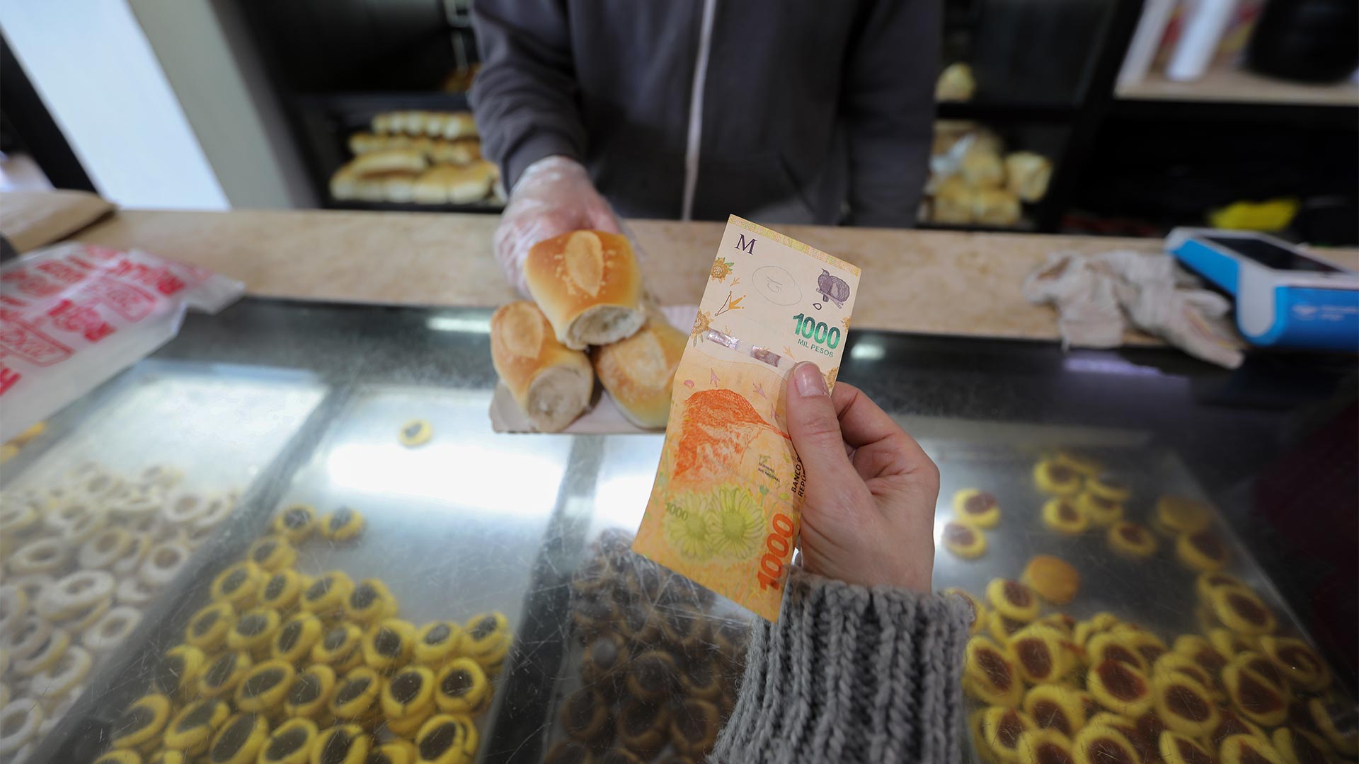 Eine Frau zahlt mit einem 1000-Peso-Schein in einer Bäckerei in Buenos Aires, Argentinien | picture alliance/dpa