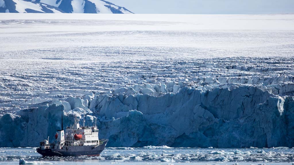 Ein Schiff vor riesigen Eisflächen in der Arktis. | picture alliance / Hinrich Bäsem
