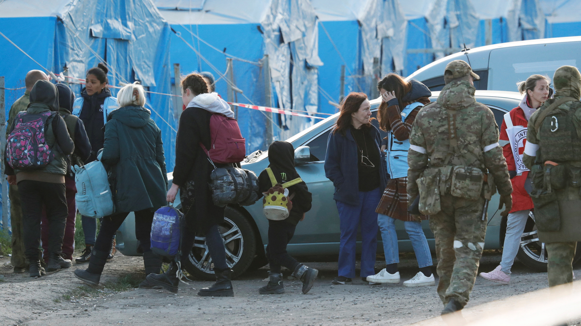 Aus dem Asow-Stahlwerk evakuierte Zivilisten kommen im ostukrainischen Dorf Bezimenne an, wo sie von Mitarbeitern des Roten Kreuzes und prorussischen Soldaten empfangen werden. | REUTERS