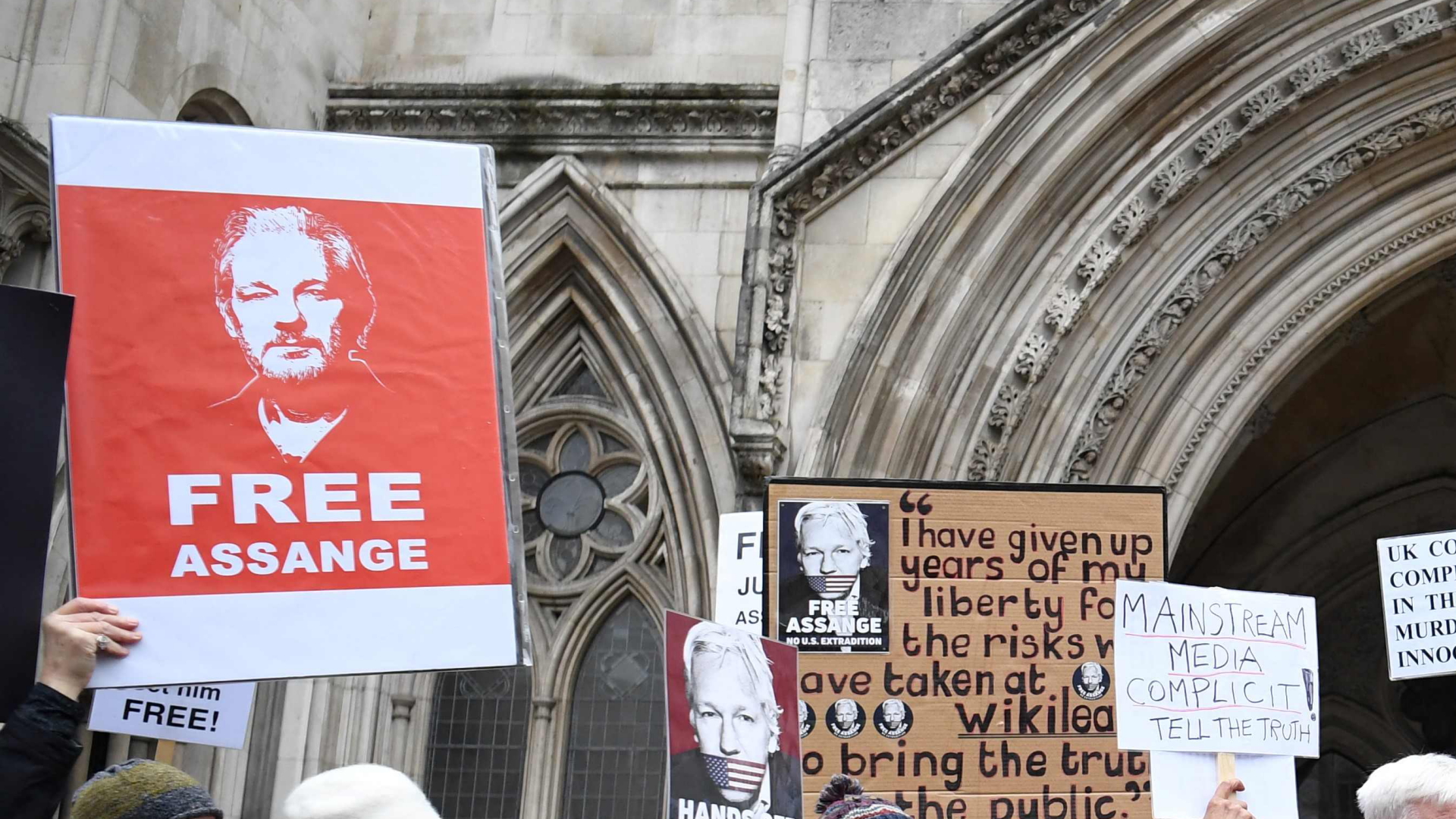 Demonstrierende halten Schilder mit der Forderung zur Freilassung von Julian Assange in die Höhe