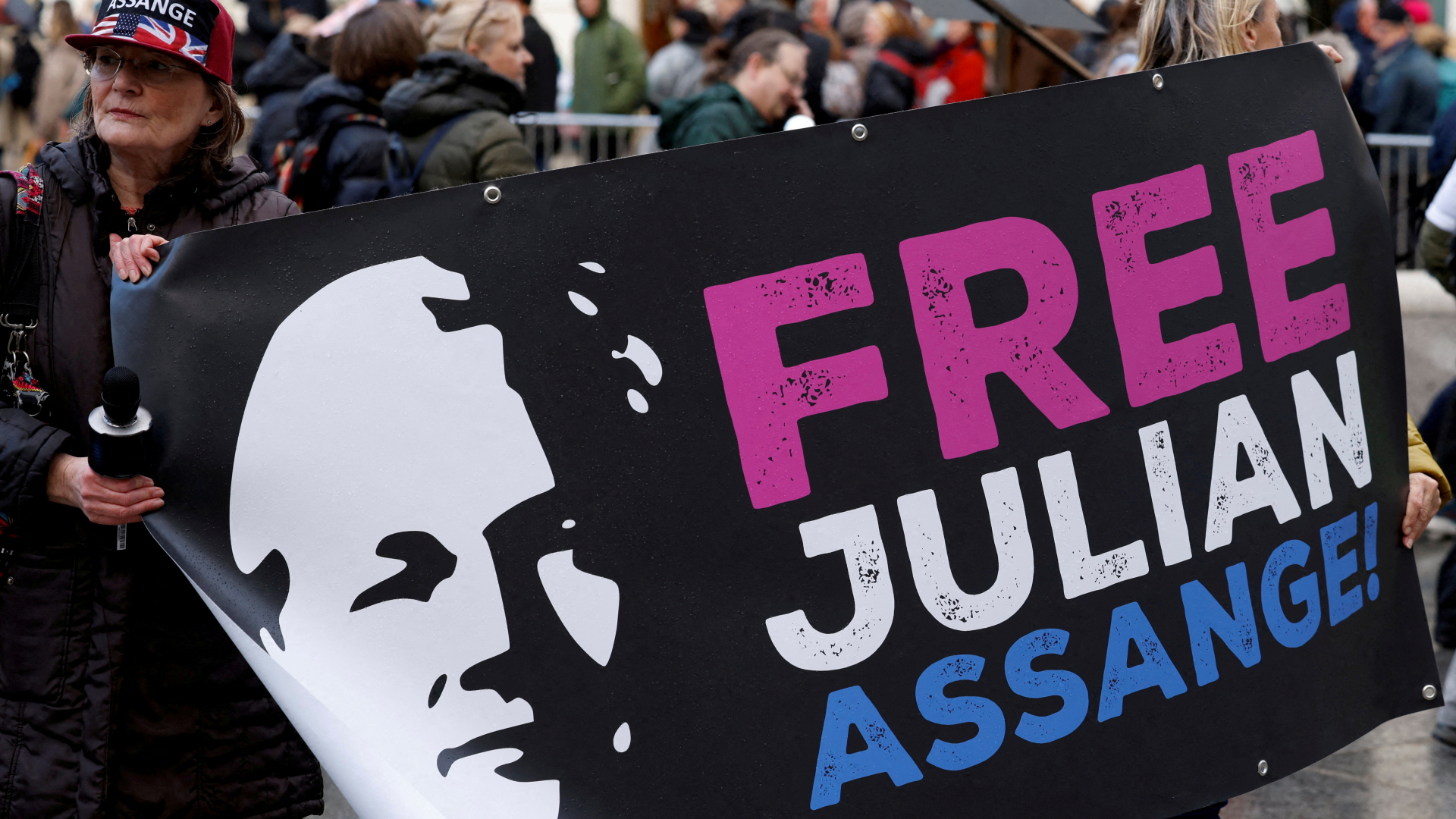 Eine Unterstützerin von Julien Assange hält in Wien ein "Lasst Julien Assange Frei"-Plakat fest