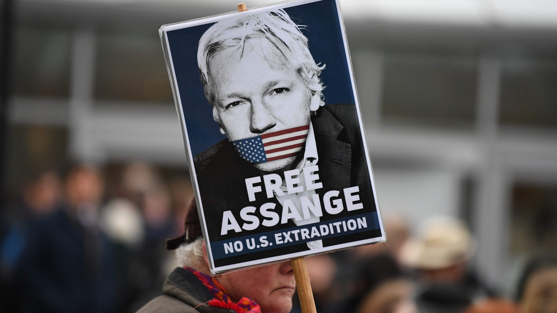 Ein  Mann mit einem Assange-Plakat vor dem Gerichtsgebäude in London.