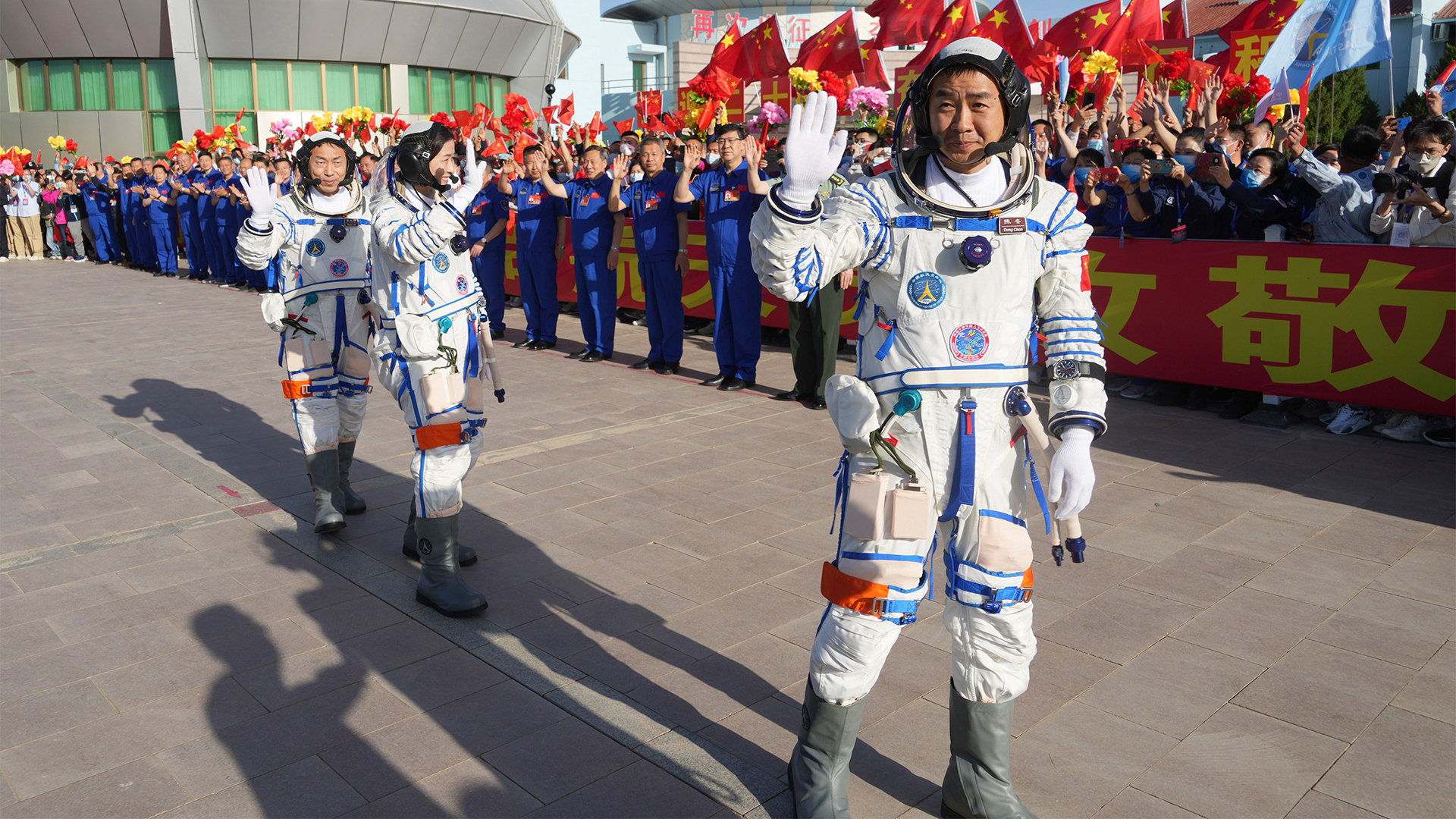 Die chinesischem Astronauten winken bei der Abschiedszeremonie für die bemannte Raumfahrtmission Shenzhou-14 im Jiuquan Satellite Launch Center.  | dpa