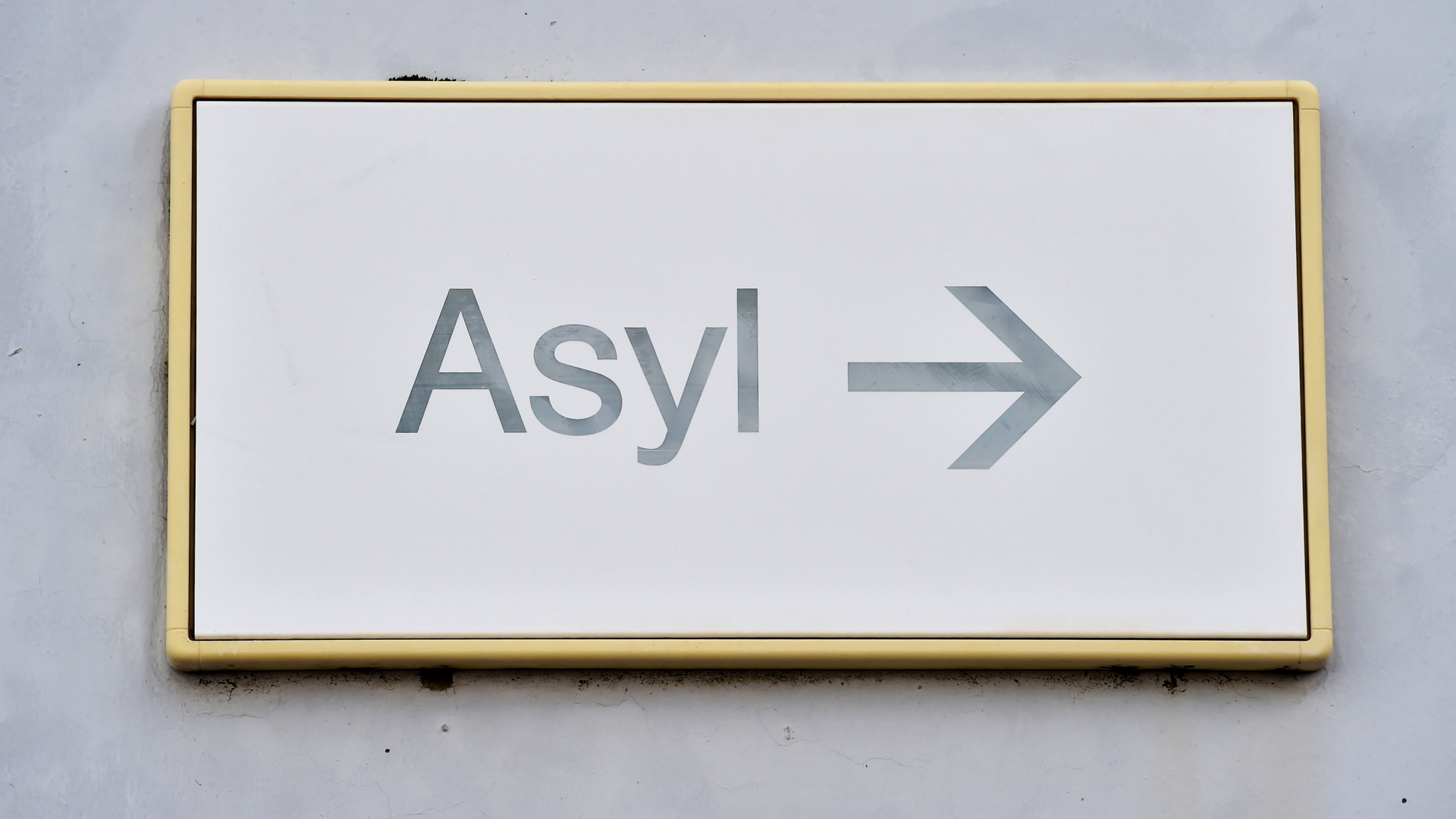 Ein Schild mit der Aufschrift "Asyl" hängt in der Landeserstaufnahme für Asylbewerber (LEA) an einer Wand.  | Bildquelle: dpa