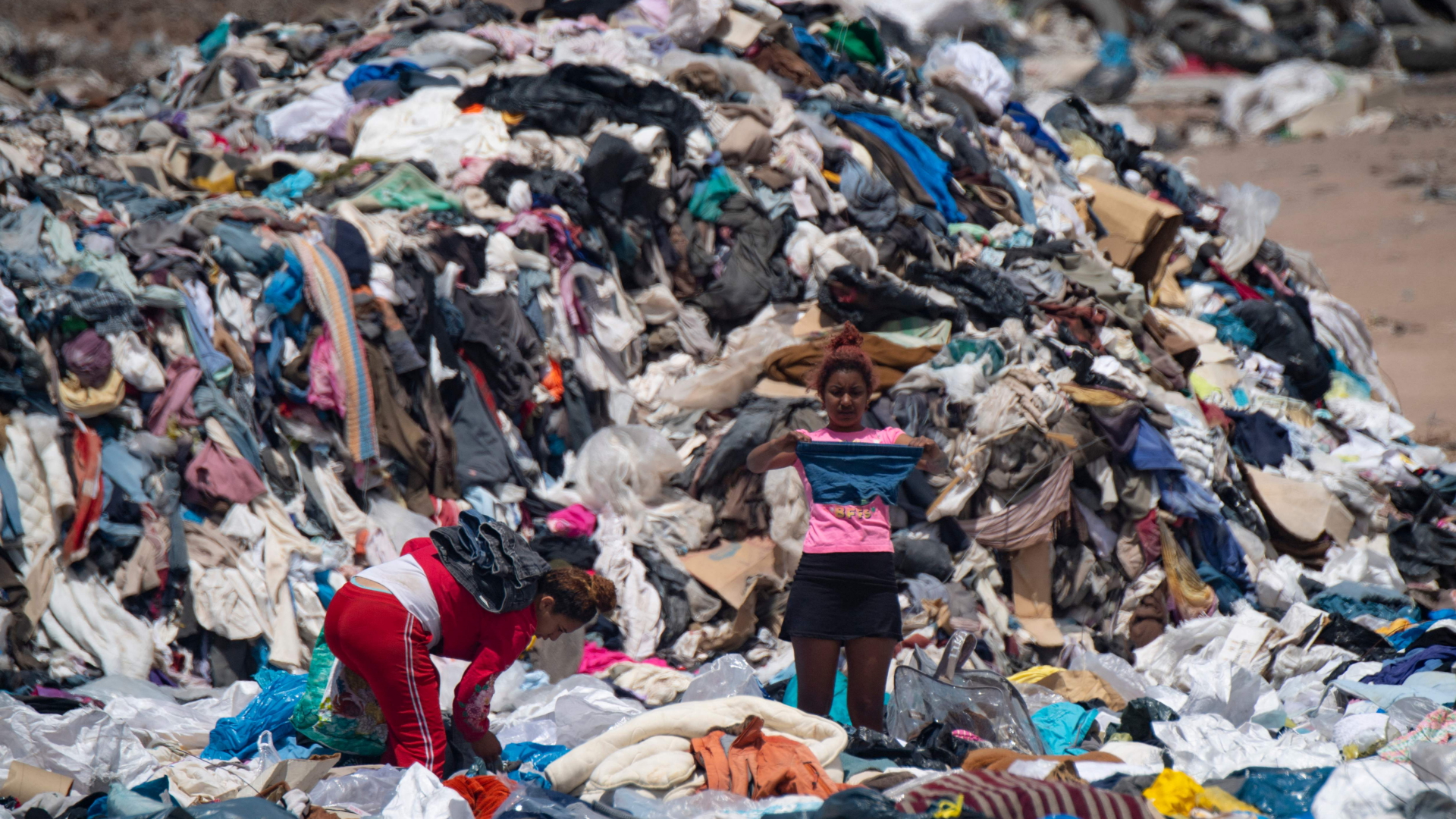 Junge Frauen suchen in Müllbergen in der Atacama-Wüste nach noch brauchbaren Kleidungsstücken. | AFP