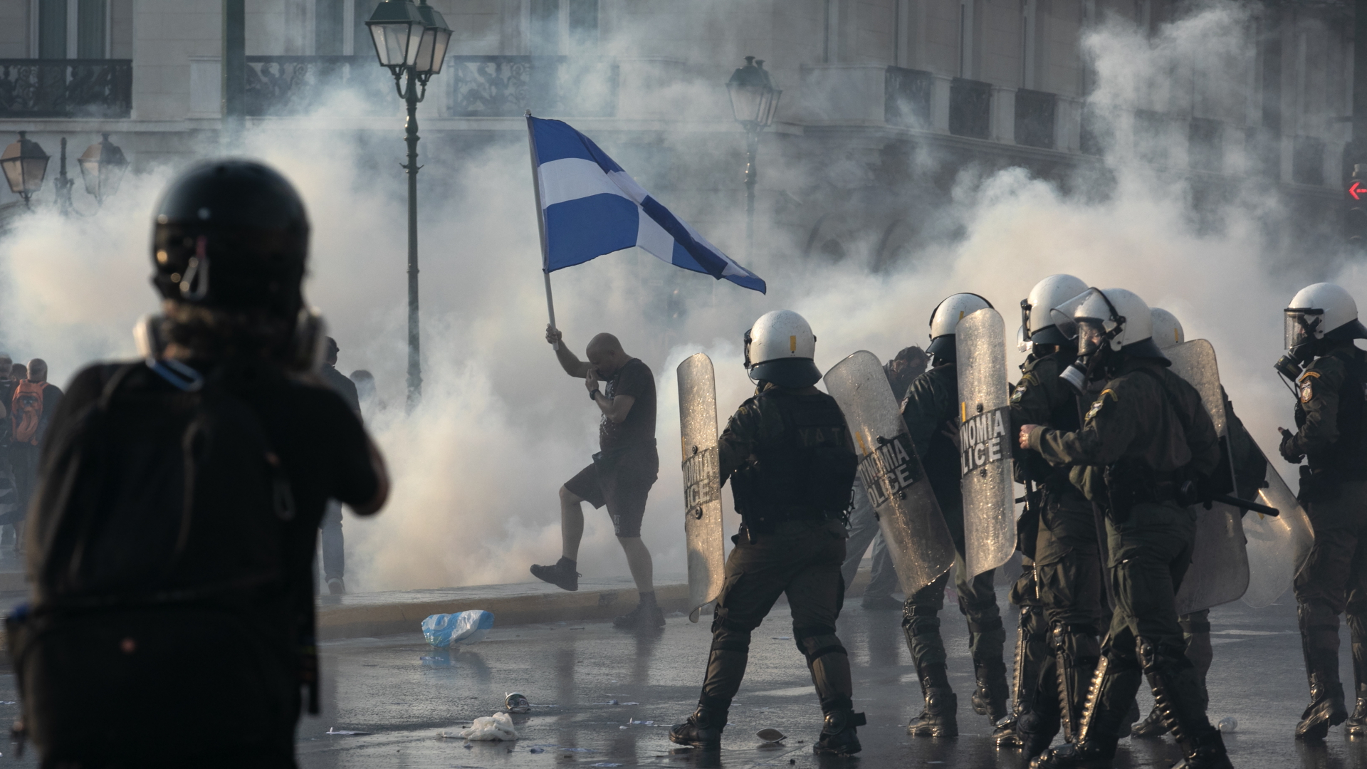Polizisten in Athen stehen aufgereiht den Demonstranten gegenüber. | dpa