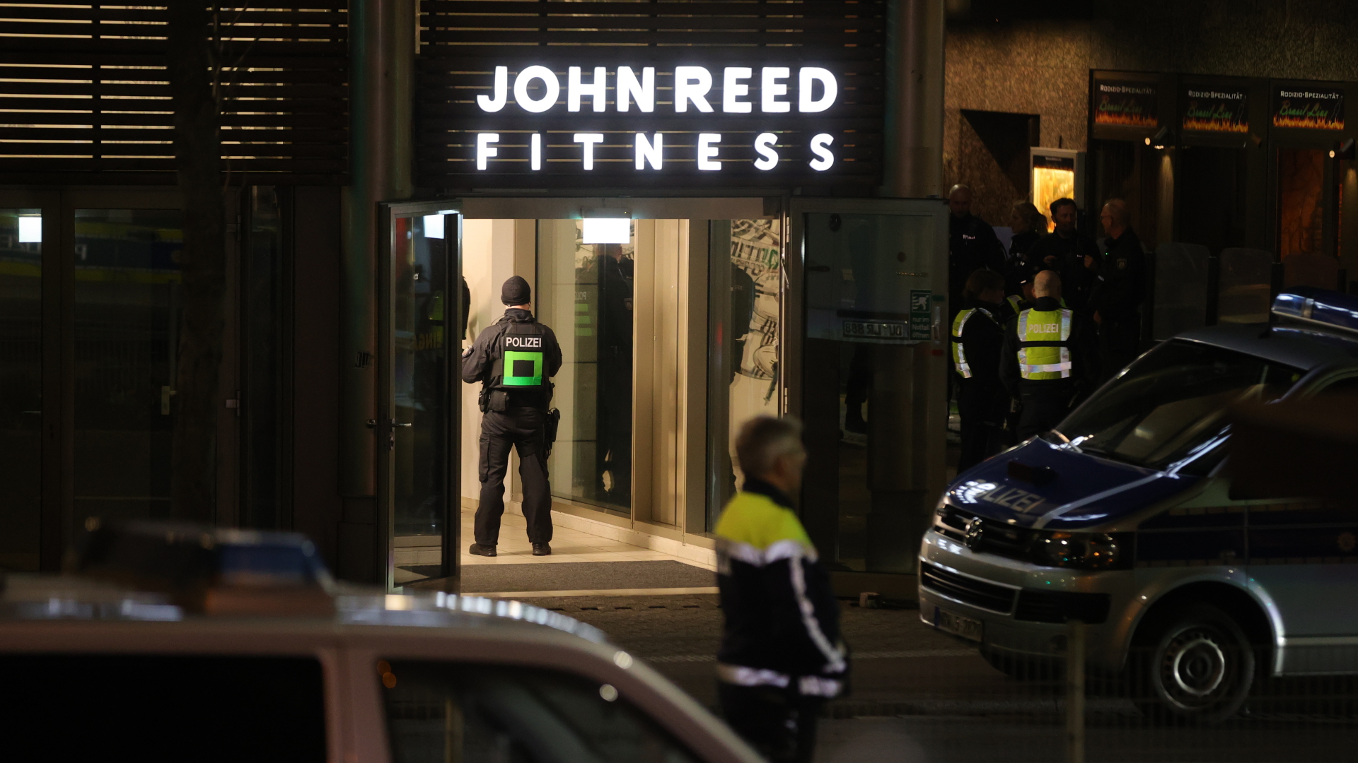 Polizisten und Polizeiautos stehen nach einem Angriff vor einem Fitnessstudio in Duisburg. | EPA