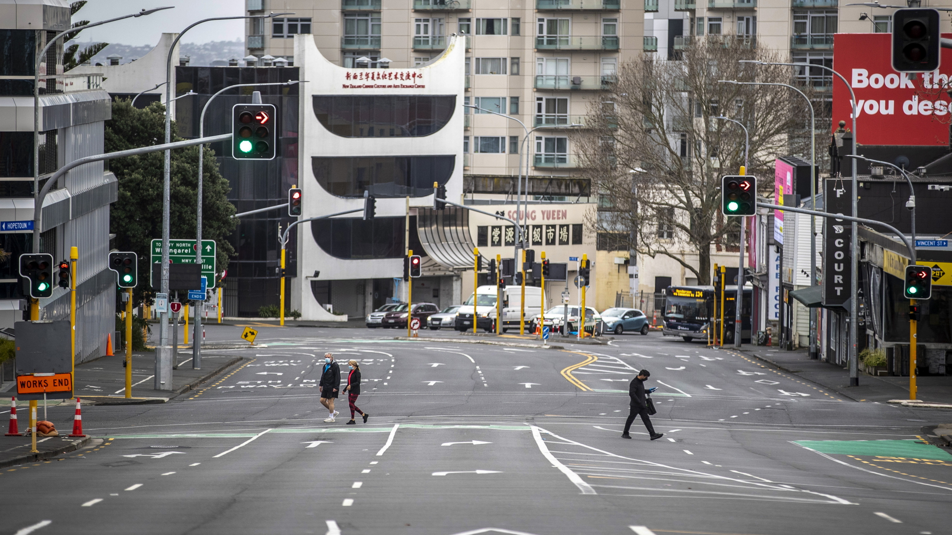 Menschen überqueren im zentralen Geschäftsviertel fast leere Straßen in Auckland, Neuseeland. | dpa