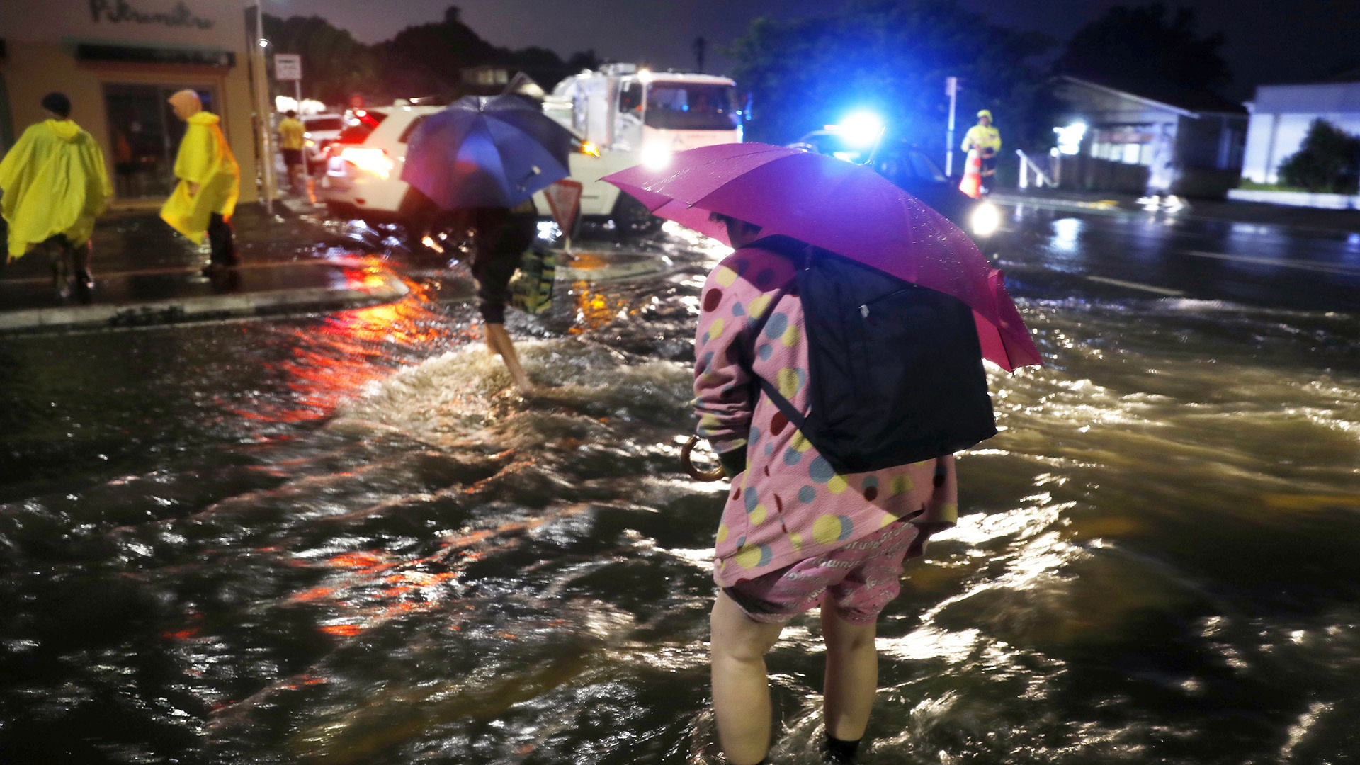 Menschen in Auckland überqueren in der Nacht eine überflutete Straße, Neuseeland | dpa