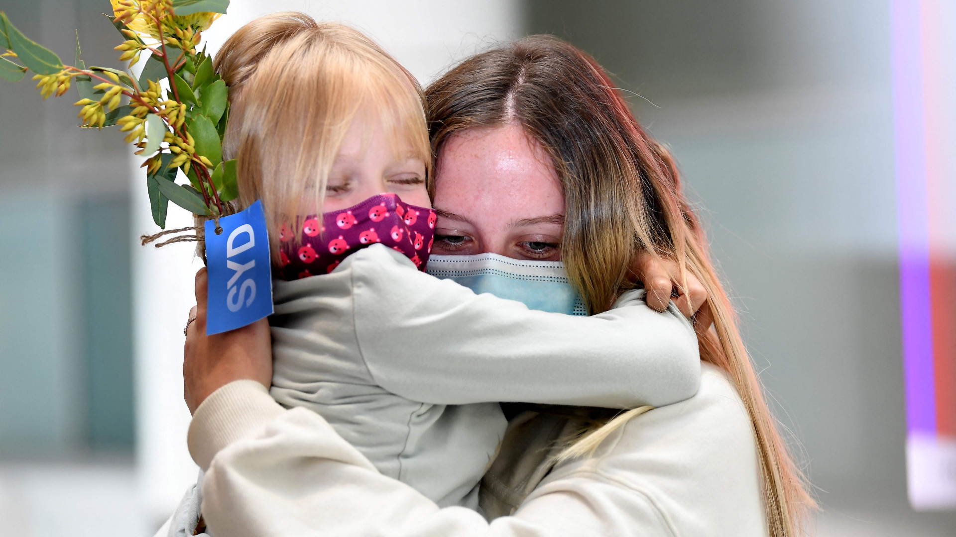 Am Flughafen Sydney schließen sich Familienmitglieder in die Arme | AFP