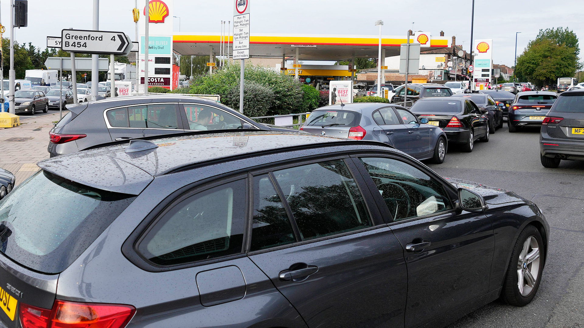 Eine lange Reihe Autos wartet vor einer Tankstelle in London.