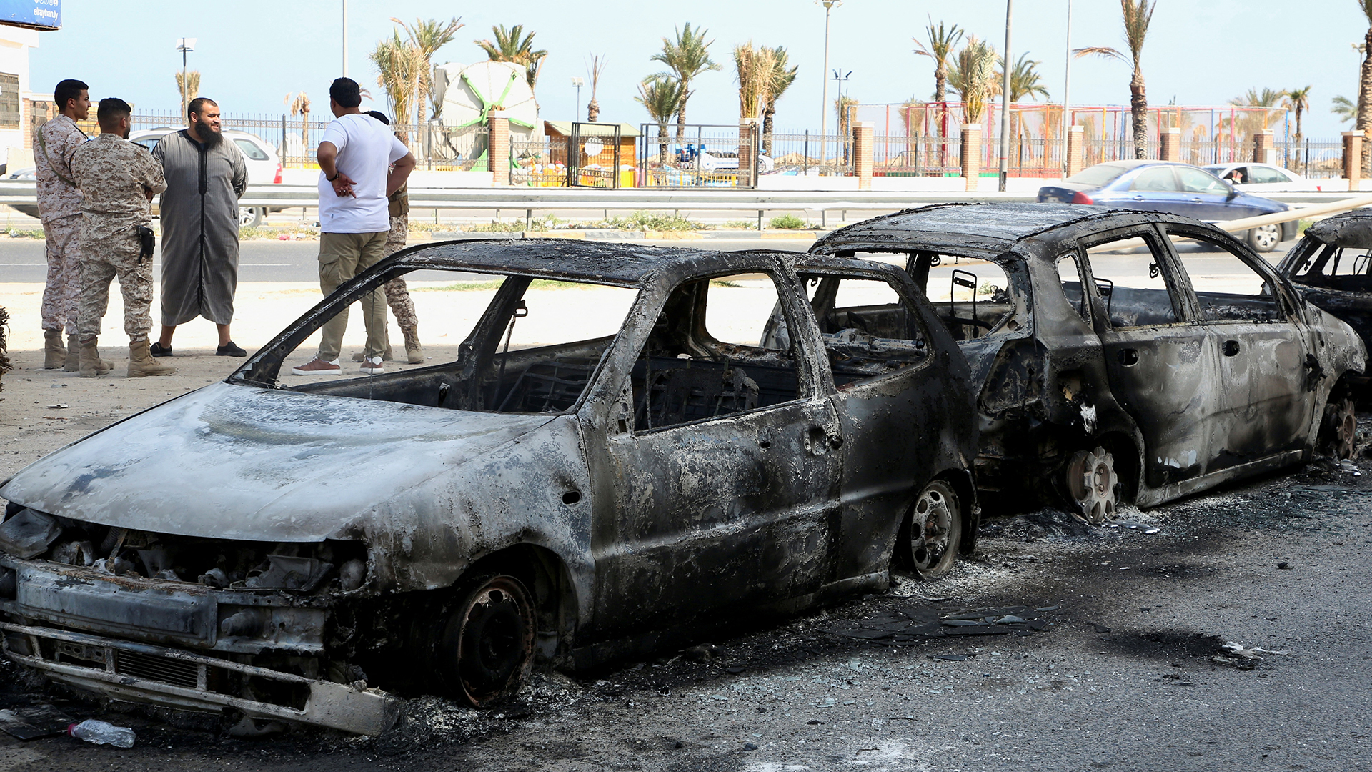 Eine Reihe verbrannter Autos steht an einer Straße in Tripolis, Libyen. | REUTERS