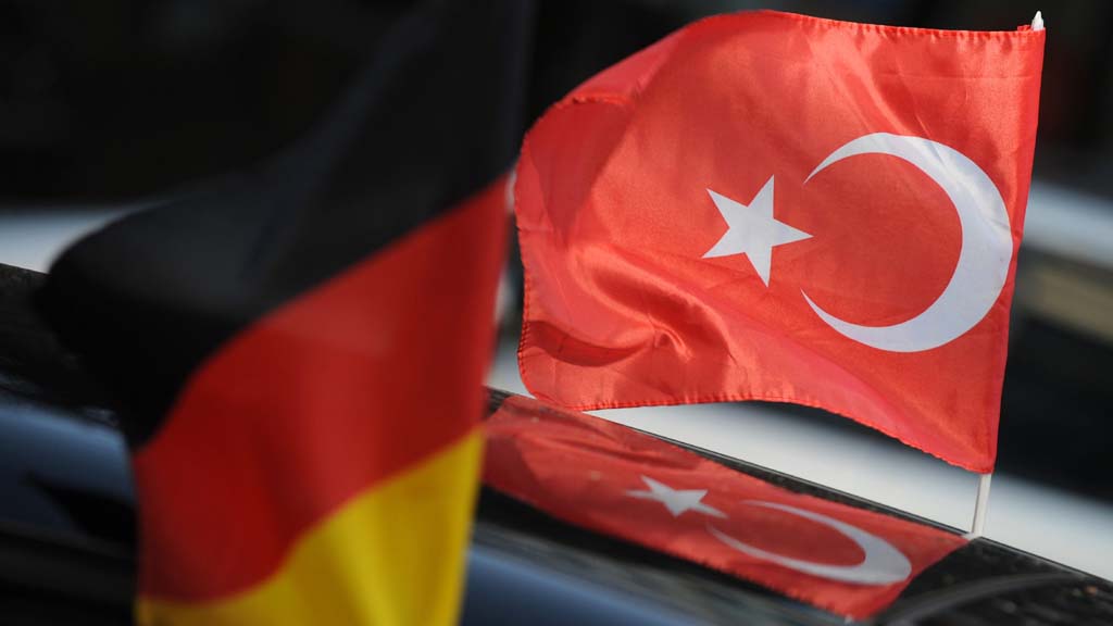 Eine deutsche und eine türkische Fahne wehen an einem Auto nebeneinander. (Archiv)