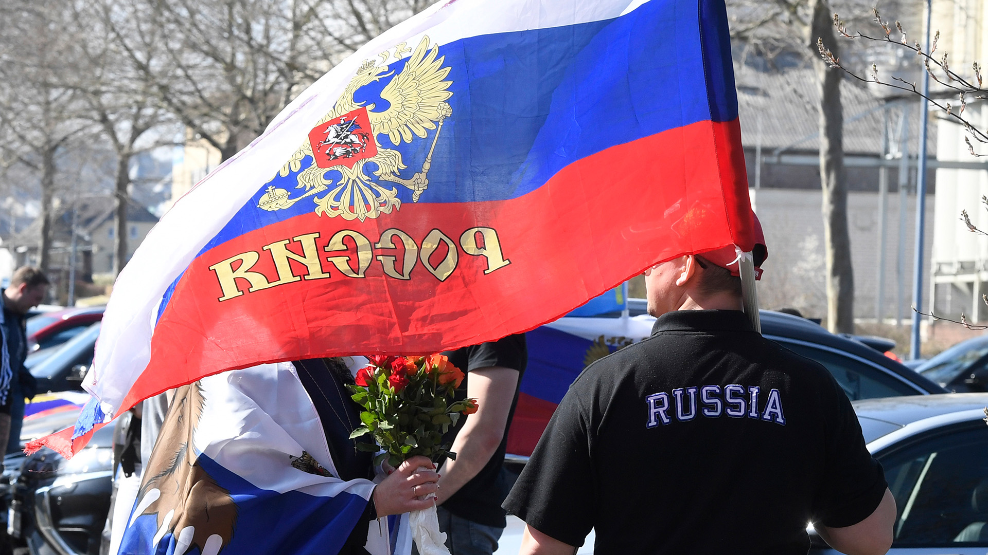 Ein Teilnehmer einer pro-russischen Demo in Bonn trägt eine russische Nationalfahne. | dpa