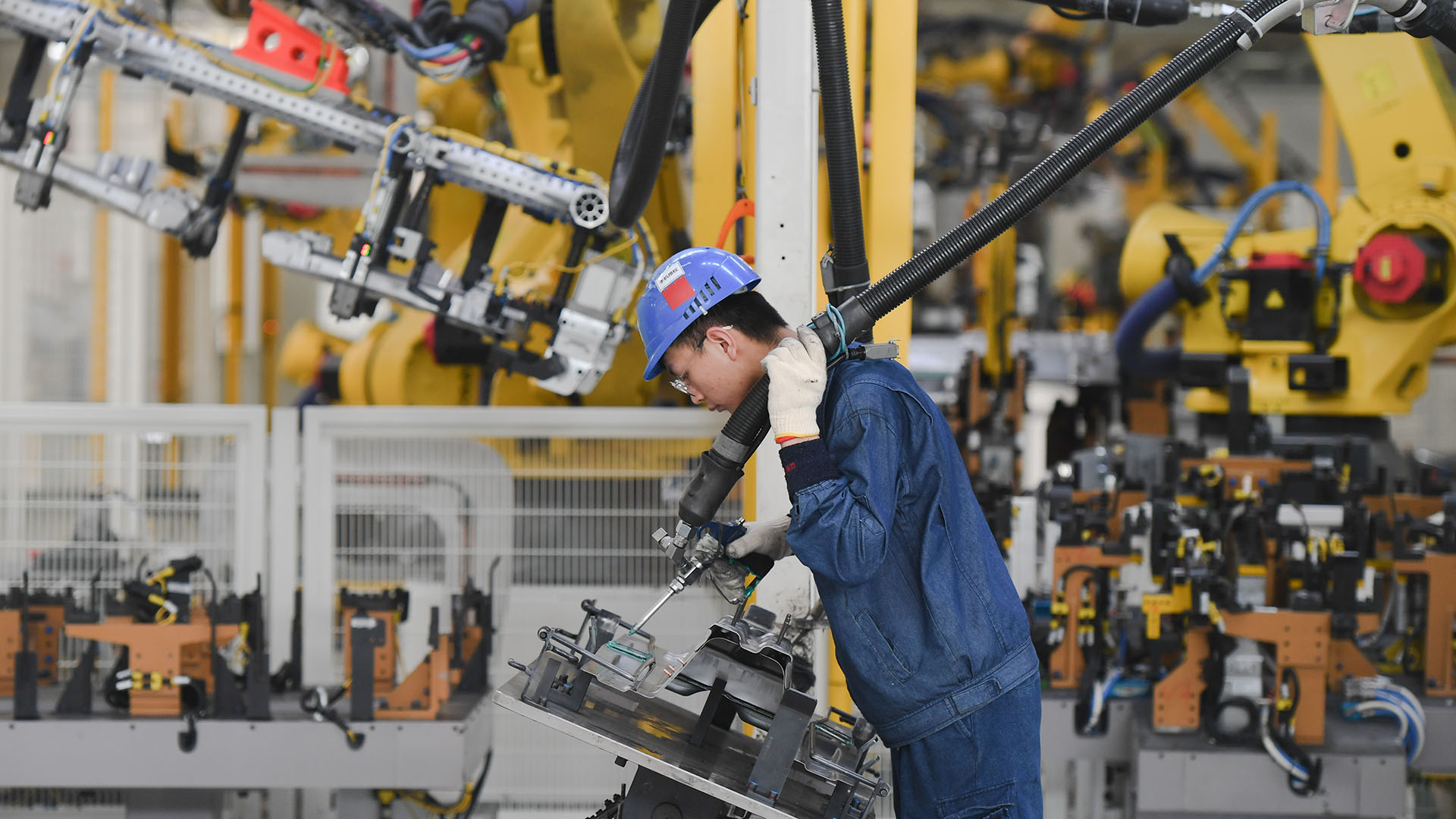 Ein Arbeiter bedient einen Roboter im PKW-Werk der SAIC Motor Corporation Ltd. in der südostchinesischen Provinz Fujian. | picture alliance/dpa/XinHua