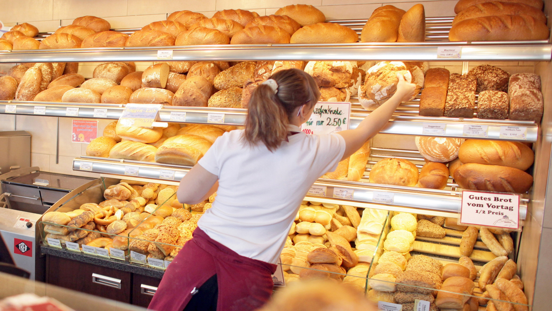 Eine Verkäuferin greift in einer Bäckerei ins Regal | dpa