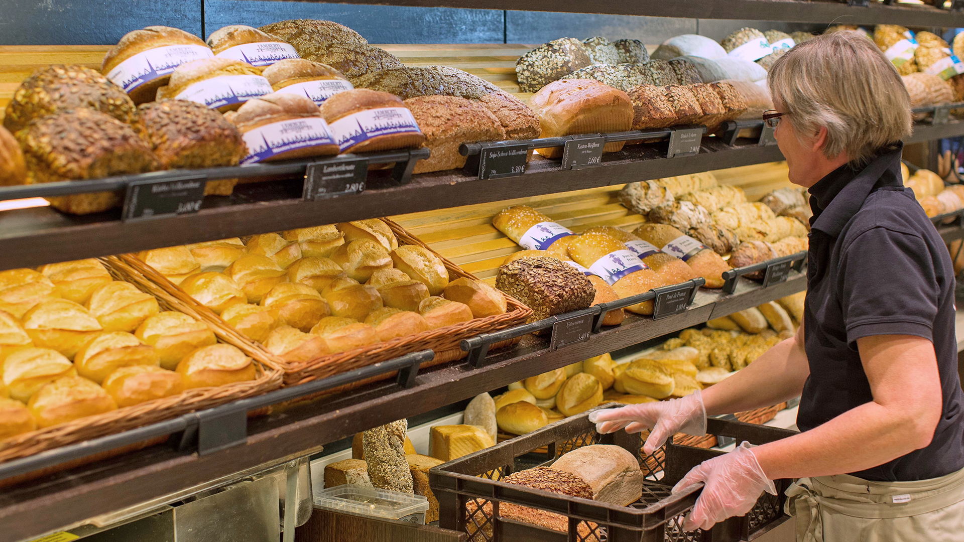 Bäckereifachverkäuferin legt Brot in die Auslage | picture alliance/dpa
