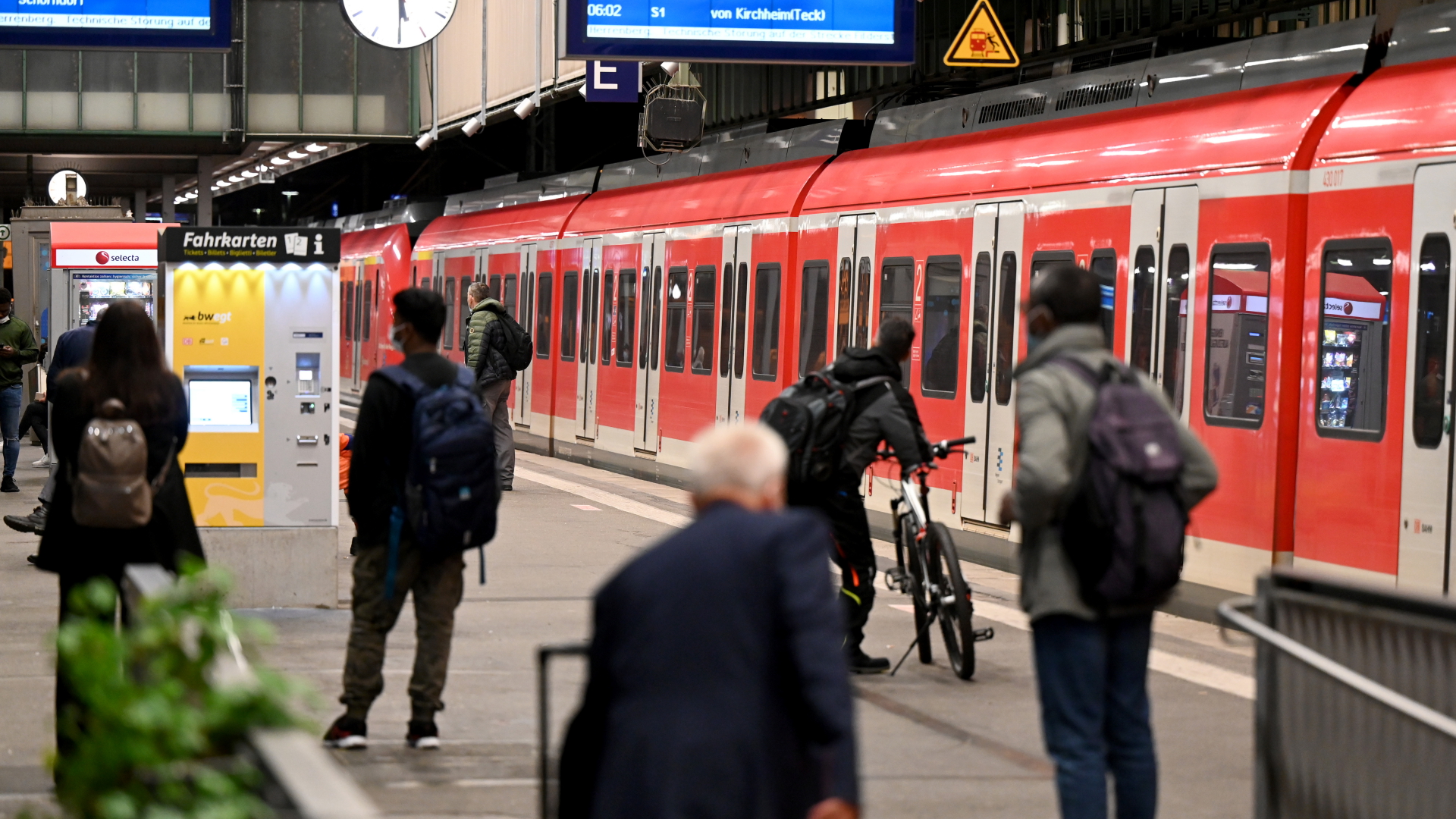 Reisende warten auf dem Bahnhof in Stuttgart auf ihren Zug. 