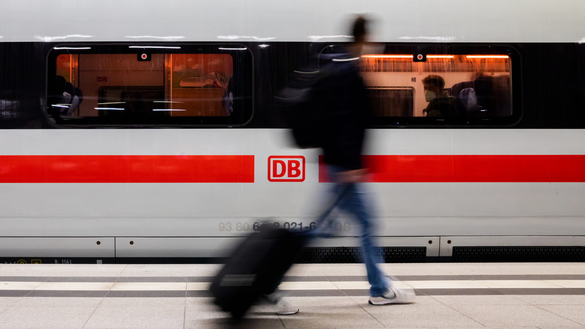 Ein Zugreisender geht vor einem ICE im Berliner Hauptbahnhof entlang. | dpa