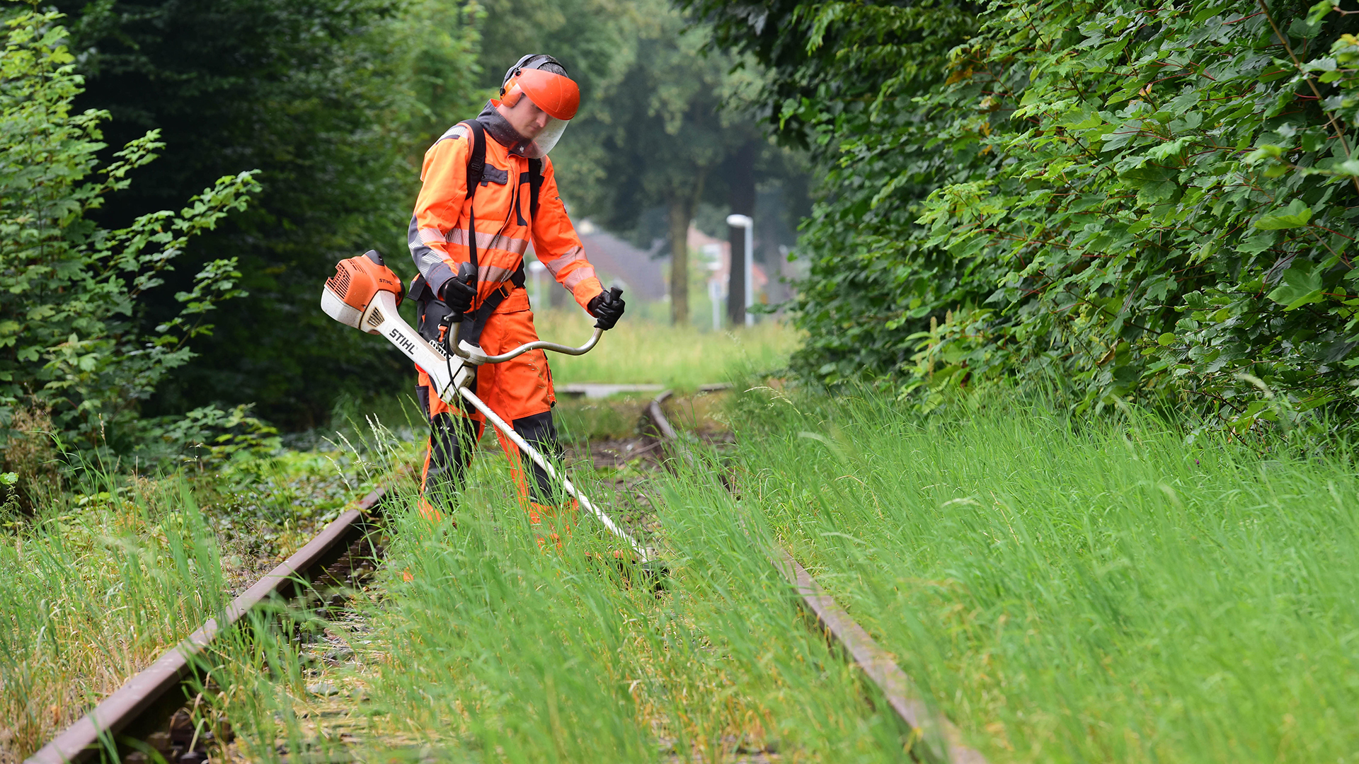 Ein Mitarbeiter der Lappwaldbahn Gleisbau GmbH mäht am Bahnhof das wild wachsende Gras zwischen den Gleisen | dpa