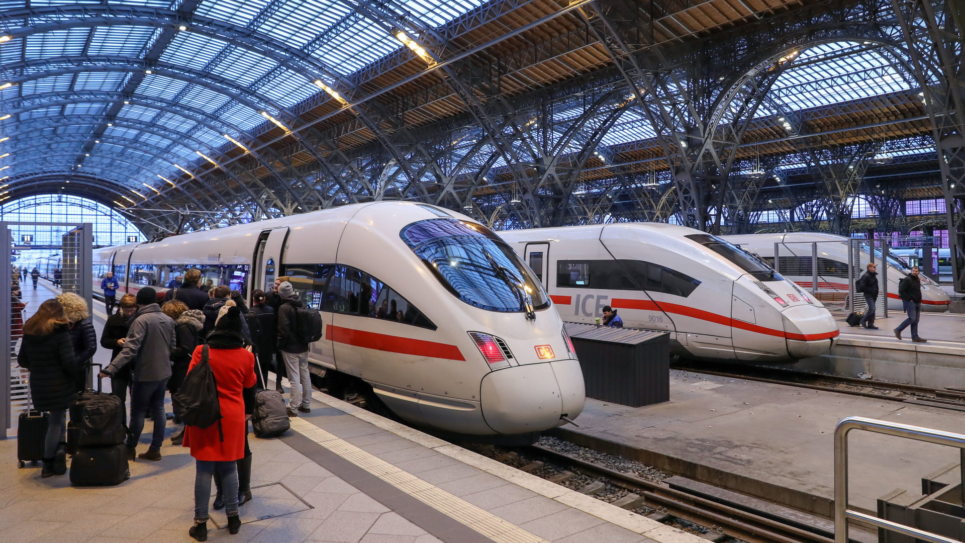 Reisende vor Zügen im Bahnhof Leipzig